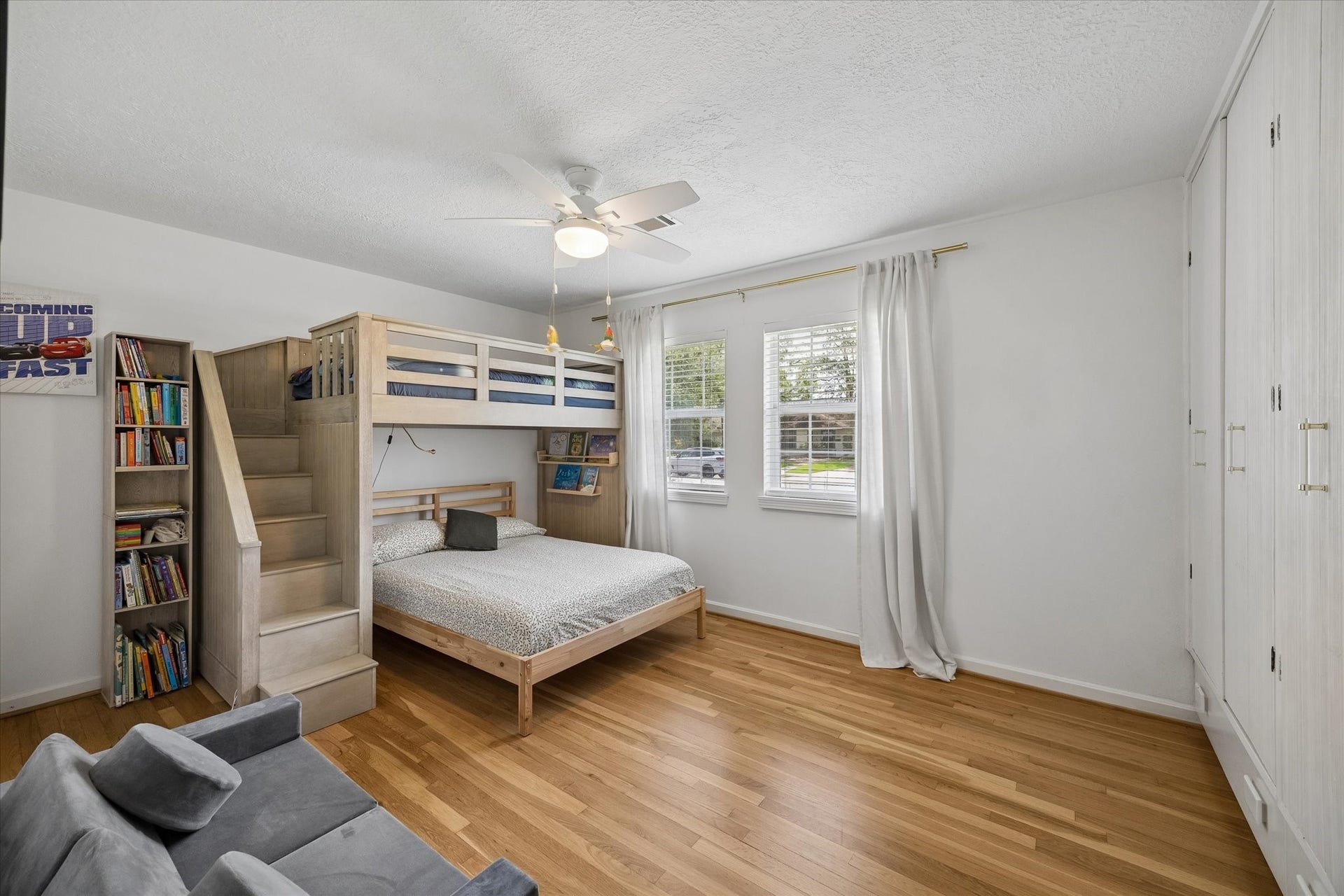 Spacious secondary bedroom with hardwood floors, abundant natural light, and built in storage for added functionality.