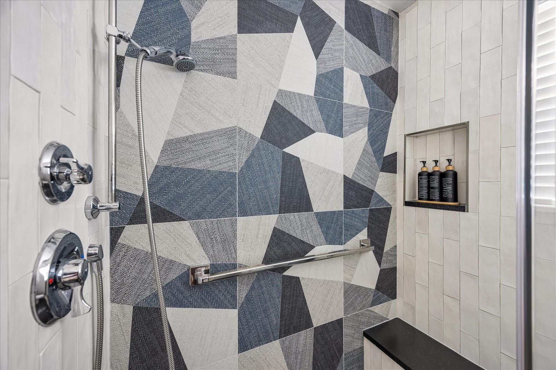 4130 Costa Rica Road, Houston, TX 77092 Striking geometric tile creates a beautiful focal point in the shower, complete with a built-in bench and recessed niche.