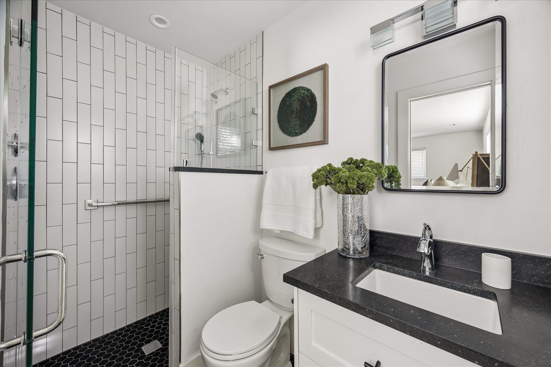 4130 Costa Rica Road, Houston, TX 77092 Beautifully updated primary bath featuring crisp white tile, a glass-enclosed shower, and contrasting dark countertops.
