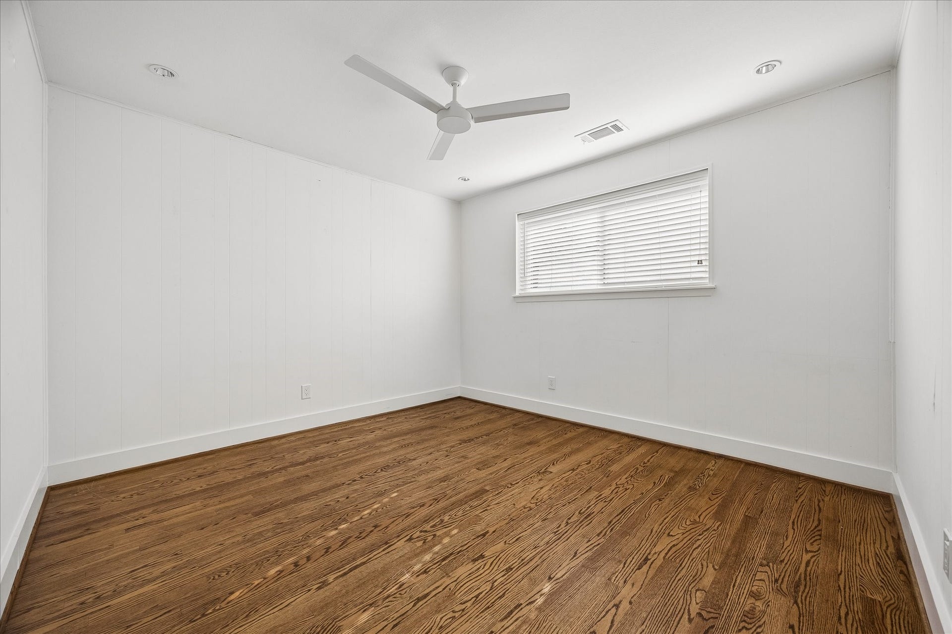 4130 Costa Rica Road, Houston, TX 77092 Fresh white painted walls, hardwood flooring, and a ceiling fan lend understated charm to this secondary bedroom.
