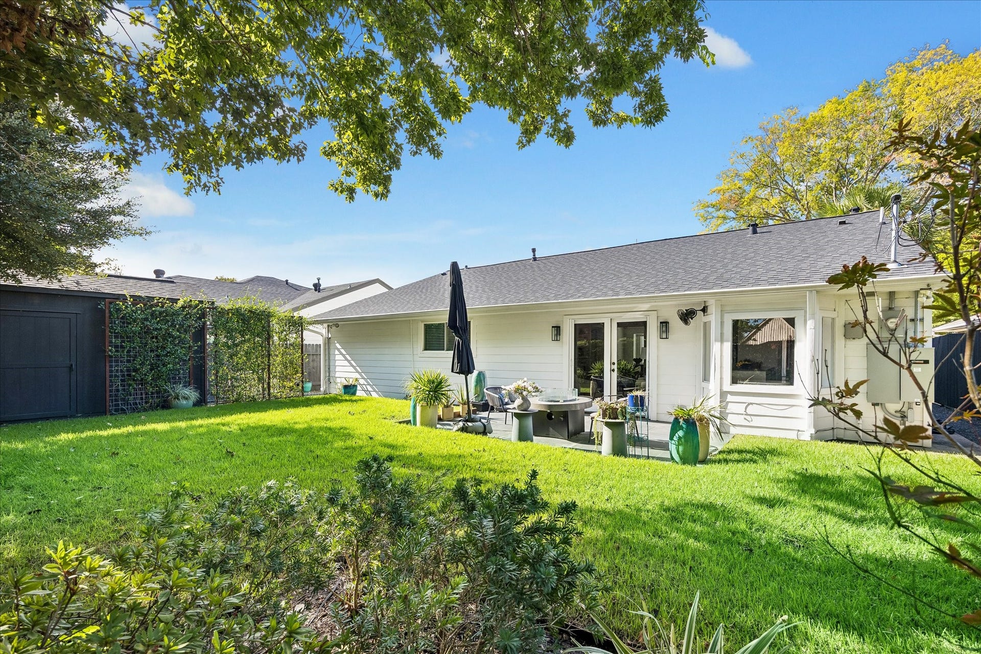 4130 Costa Rica Road, Houston, TX 77092 Layered greenery and beautifully maintained grounds offer a picturesque view of the home's rear elevation.