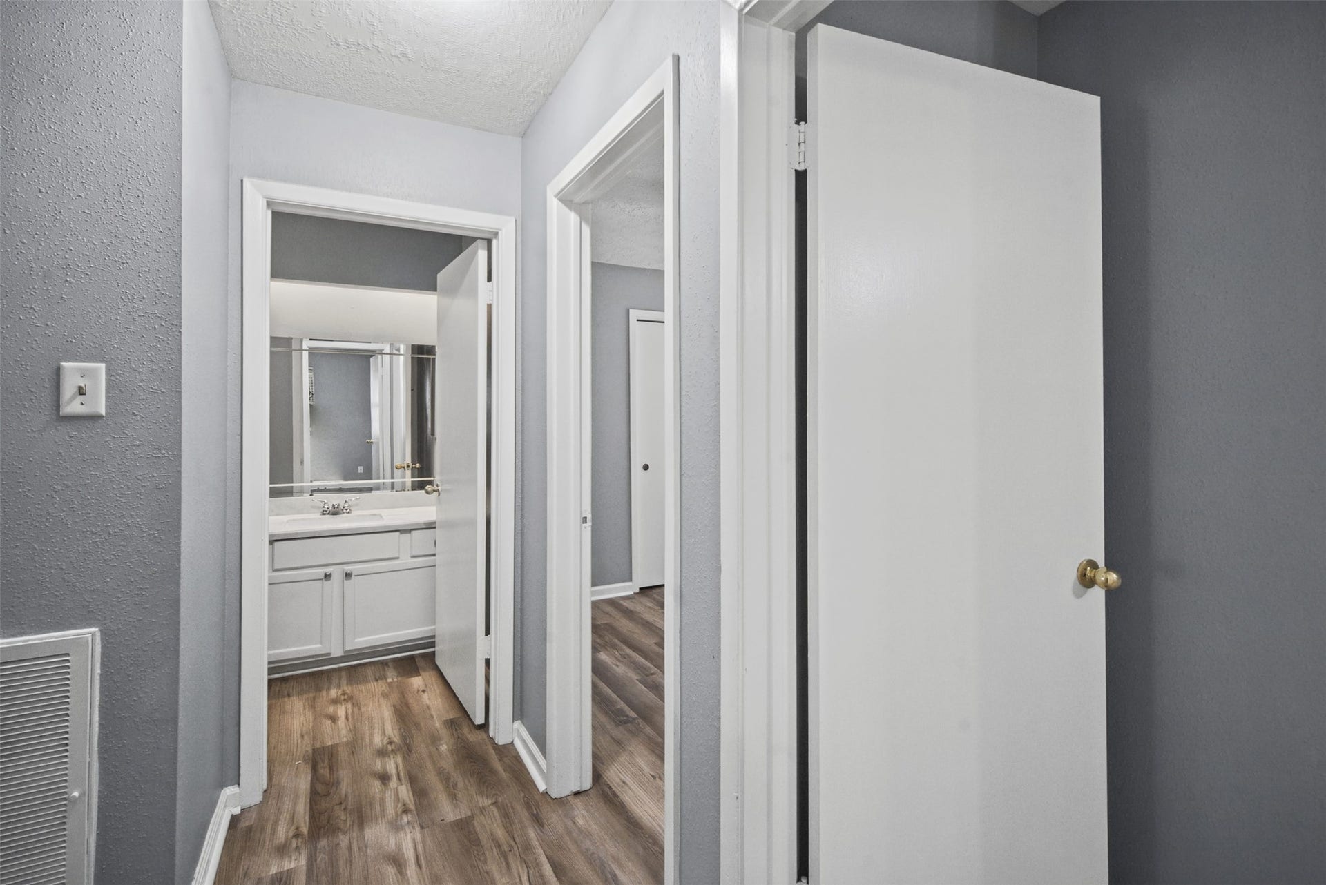 1323 Castle Glen Drive, Houston, TX 77015 Thoughtfully connected living spaces make daily routines easier! This hallway provides convenient access to the bedrooms and bathroom, with continuous wood-look flooring for a cohesive look.