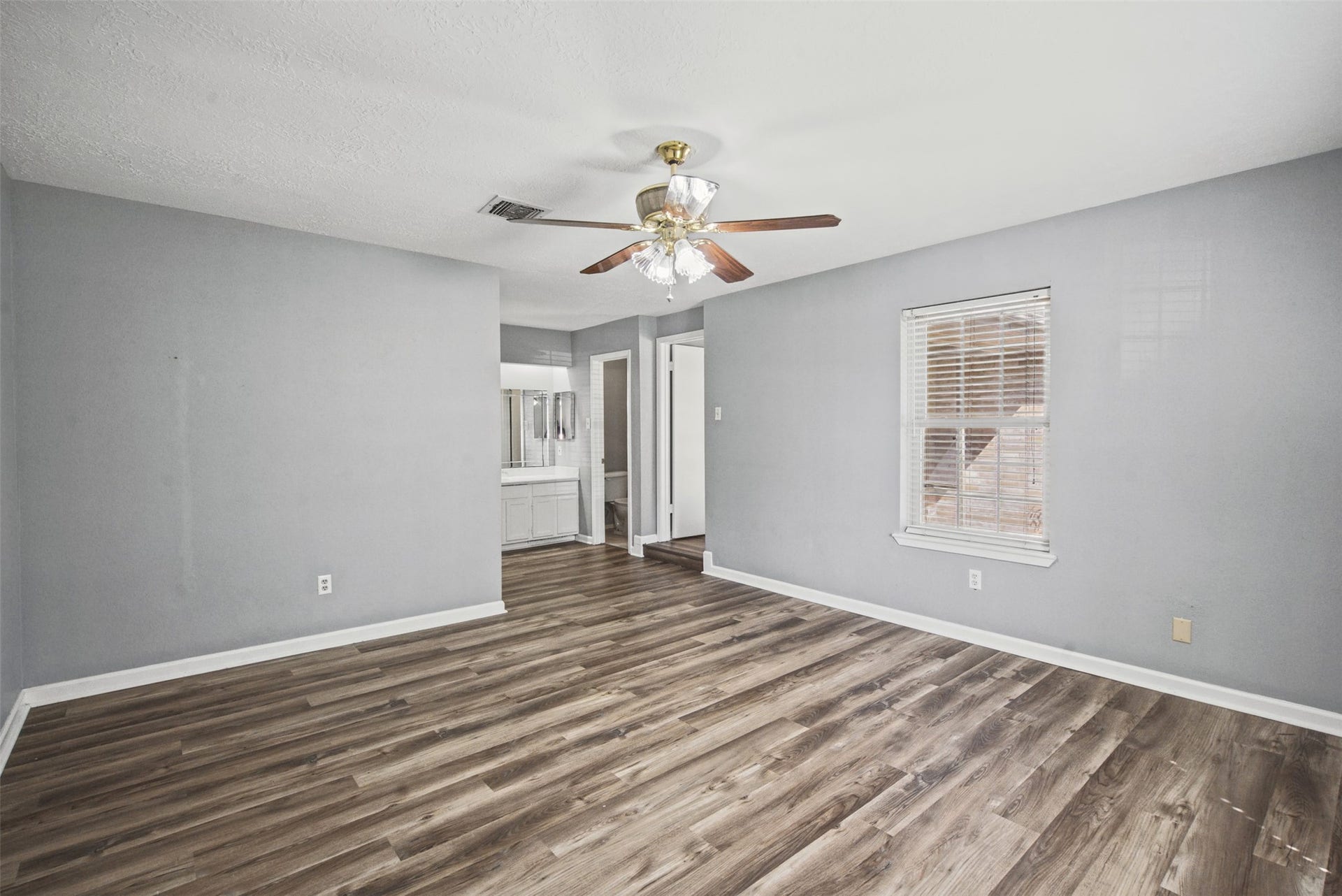 1323 Castle Glen Drive, Houston, TX 77015 Your own private escape! This generously sized primary bedroom offers room to unwind, attractive wood-look flooring, and convenient access to the vanity and bathroom area.