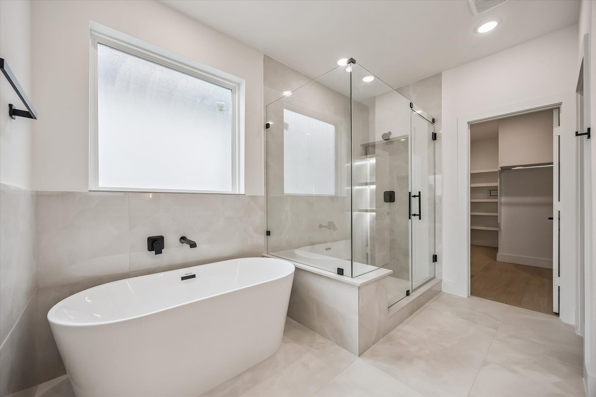 5339 Larkin Street, Houston, TX 77007 Luxurious bathroom featuring a freestanding tub, glass-enclosed shower, and sleek modern fixtures, seamlessly connected to a spacious walk-in closet.