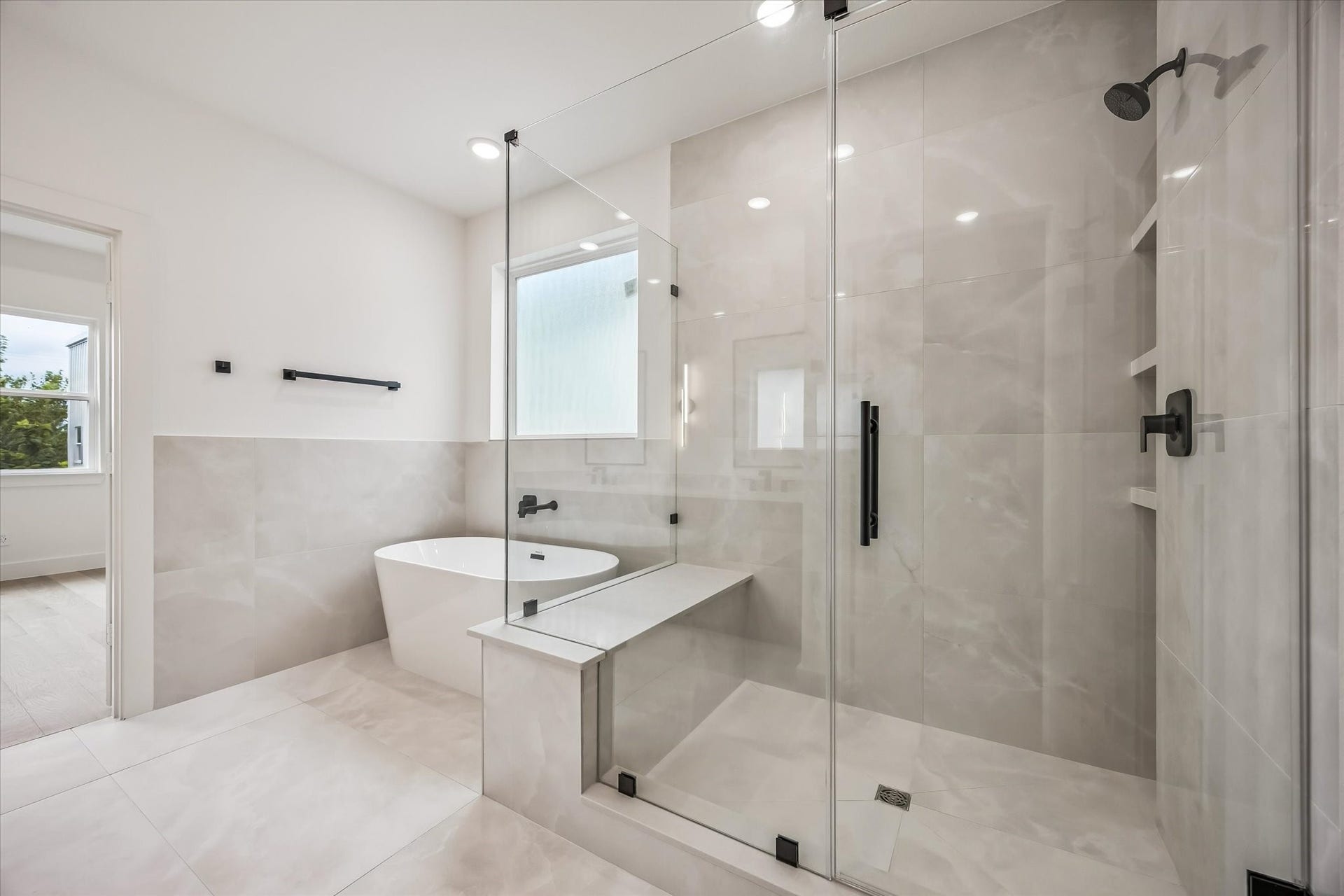 5339 Larkin Street, Houston, TX 77007 Luxurious bathroom featuring a spacious glass-enclosed shower, elegant soaking tub, and modern fixtures, all accented by sleek tile work and abundant natural light.