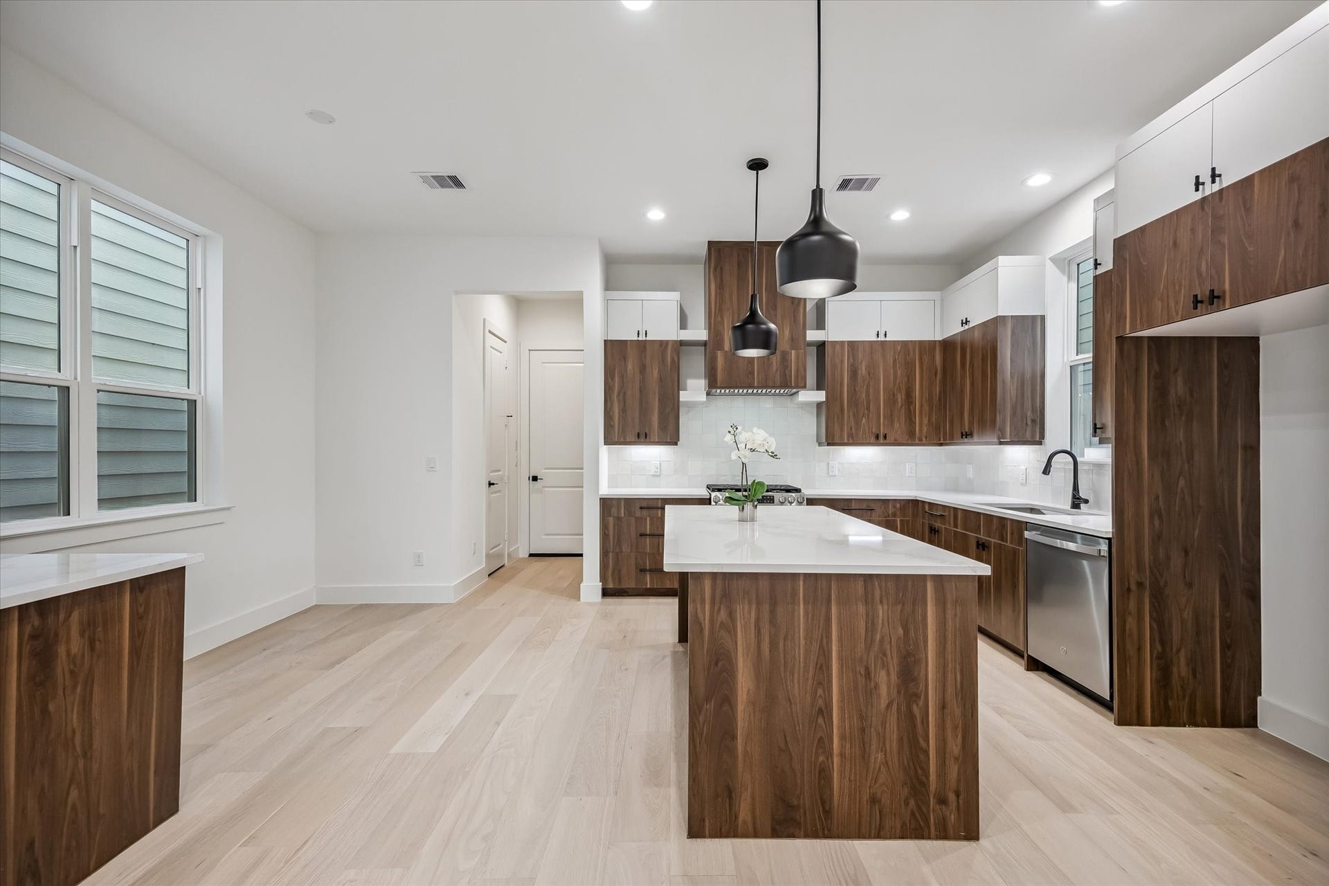 5339 Larkin Street, Houston, TX 77007 Discover a modern kitchen with sleek wood cabinetry, a spacious island, and stylish pendant lighting, complemented by stainless steel appliances and ample natural light.