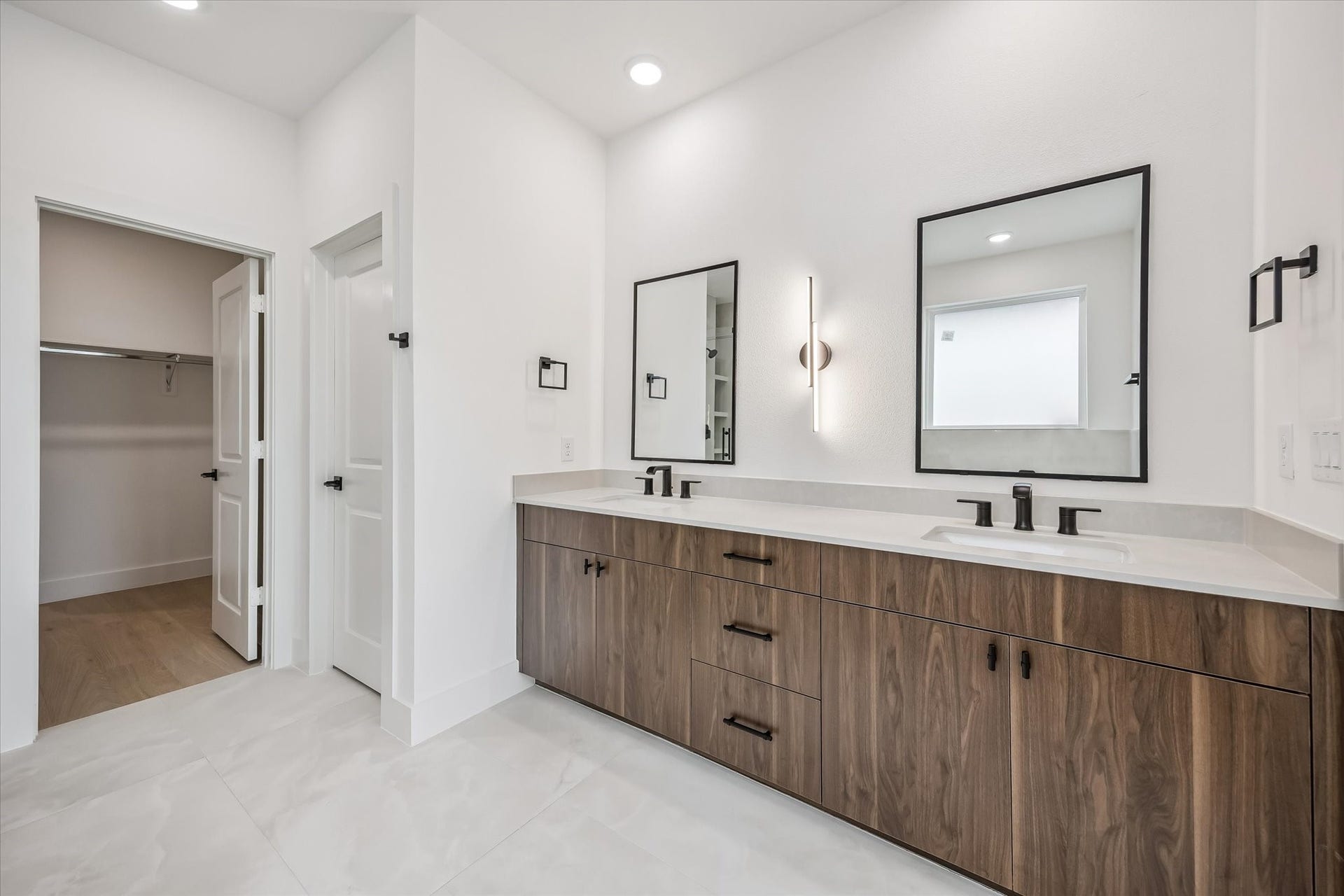 5339 Larkin Street, Houston, TX 77007 Spacious modern bathroom featuring a dual-sink vanity with sleek fixtures, elegant mirrors, and ample storage, complemented by a walk-in closet for convenience.