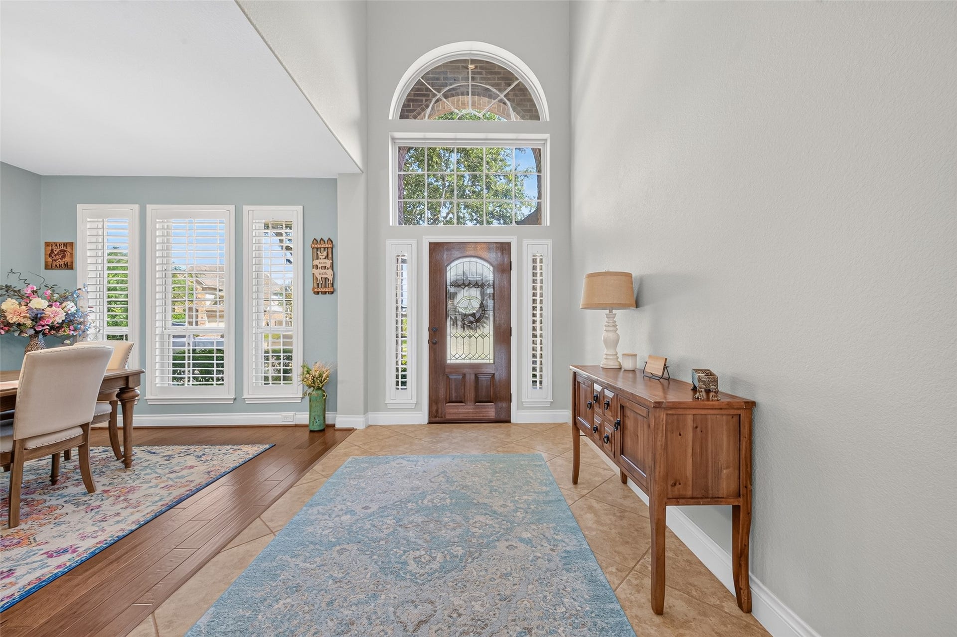 6710 Aqua Falls, Missouri City, TX 77459 Bright and inviting entryway with high ceilings, a stunning arched window above the door, and elegant wood and tile flooring.