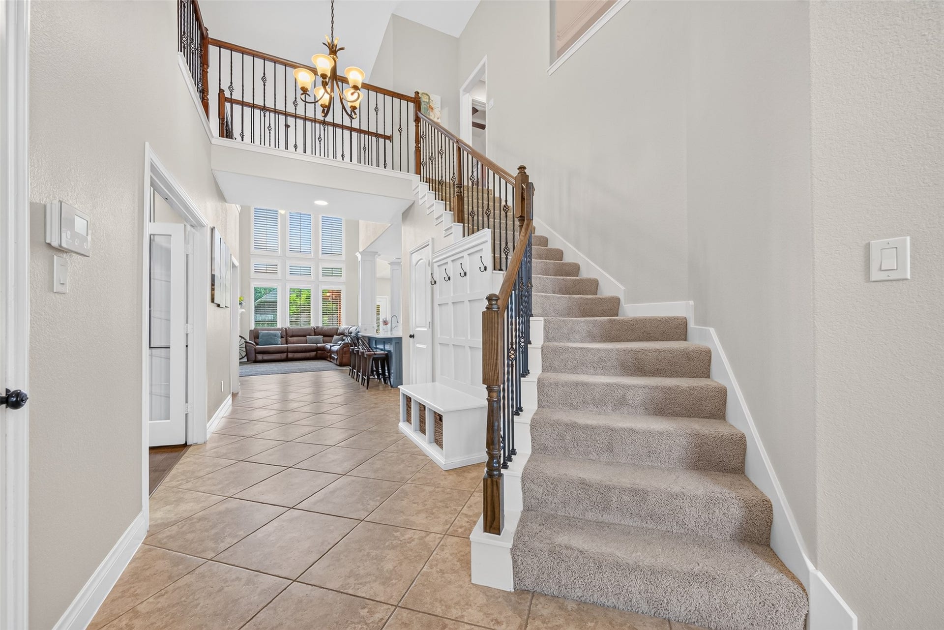 6710 Aqua Falls, Missouri City, TX 77459 Grand entryway with elegant staircase and high ceilings leads to a spacious living area filled with natural light from large windows, creating an inviting and open atmosphere.