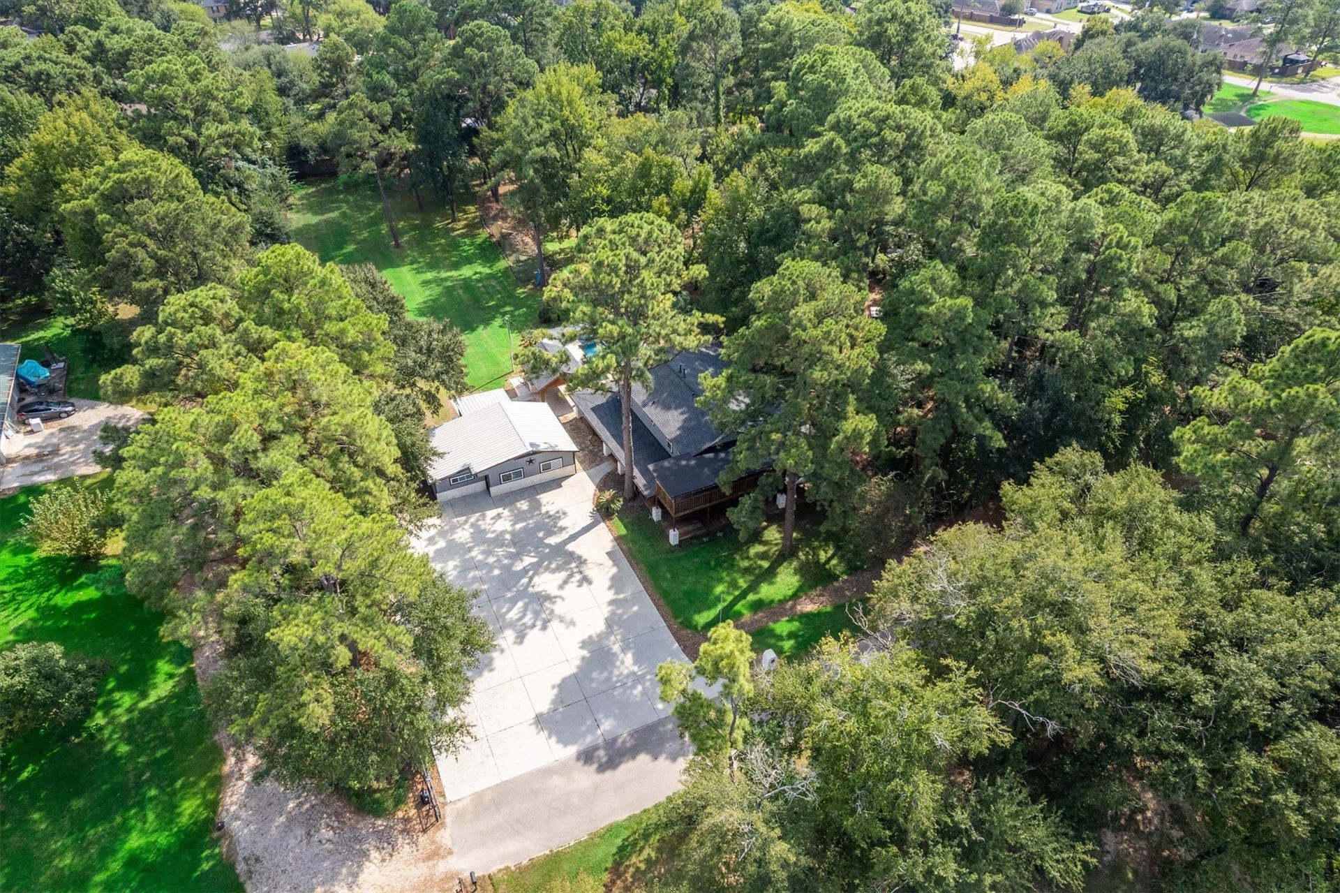 7119 Poole Road, Spring, TX 77379 This aerial view showcases the propertys wooded surroundings and expansive outdoor areas.
