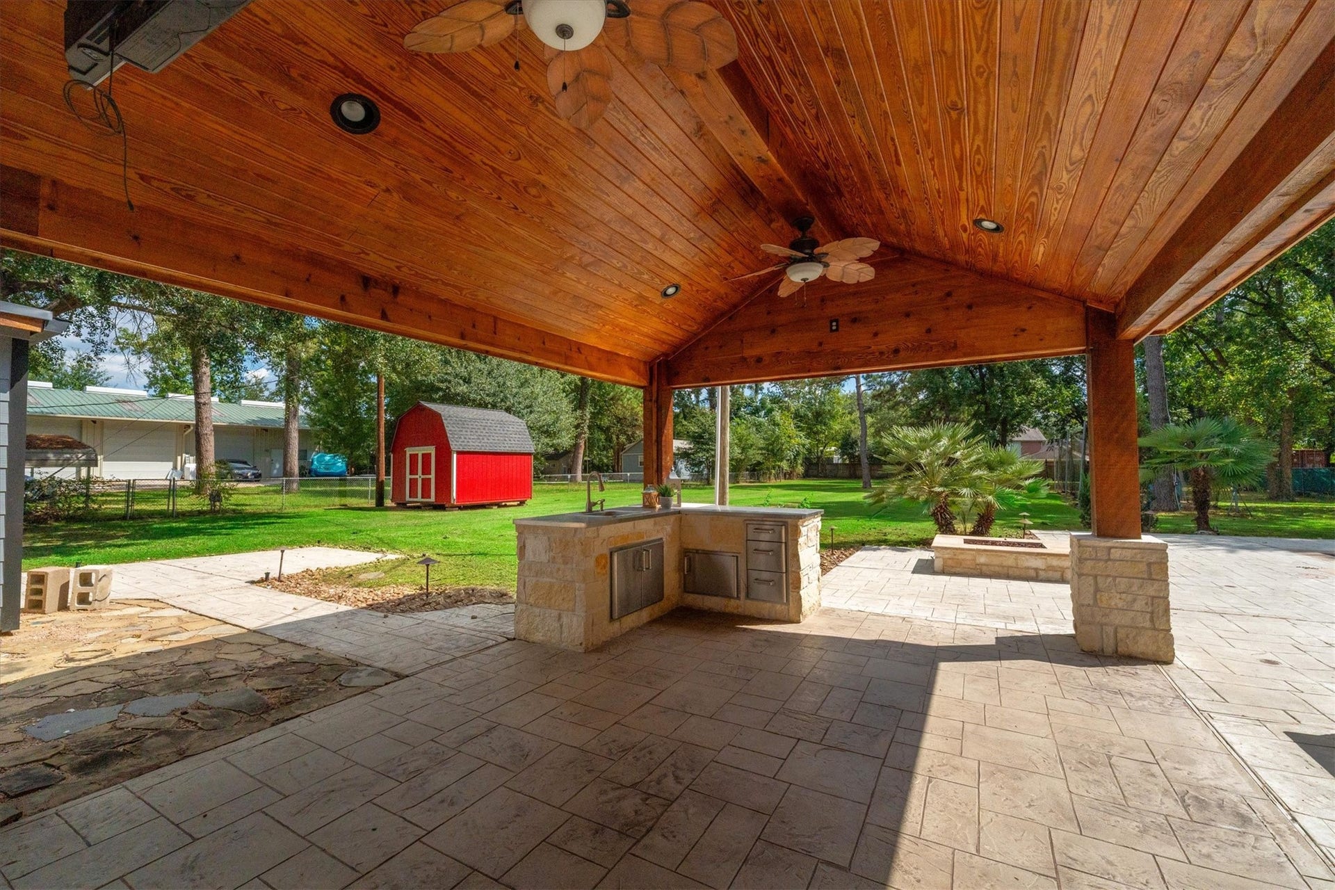 7119 Poole Road, Spring, TX 77379 A beautiful wood-plank ceiling and travertine tile add warmth and character to the outdoor kitchen area.
