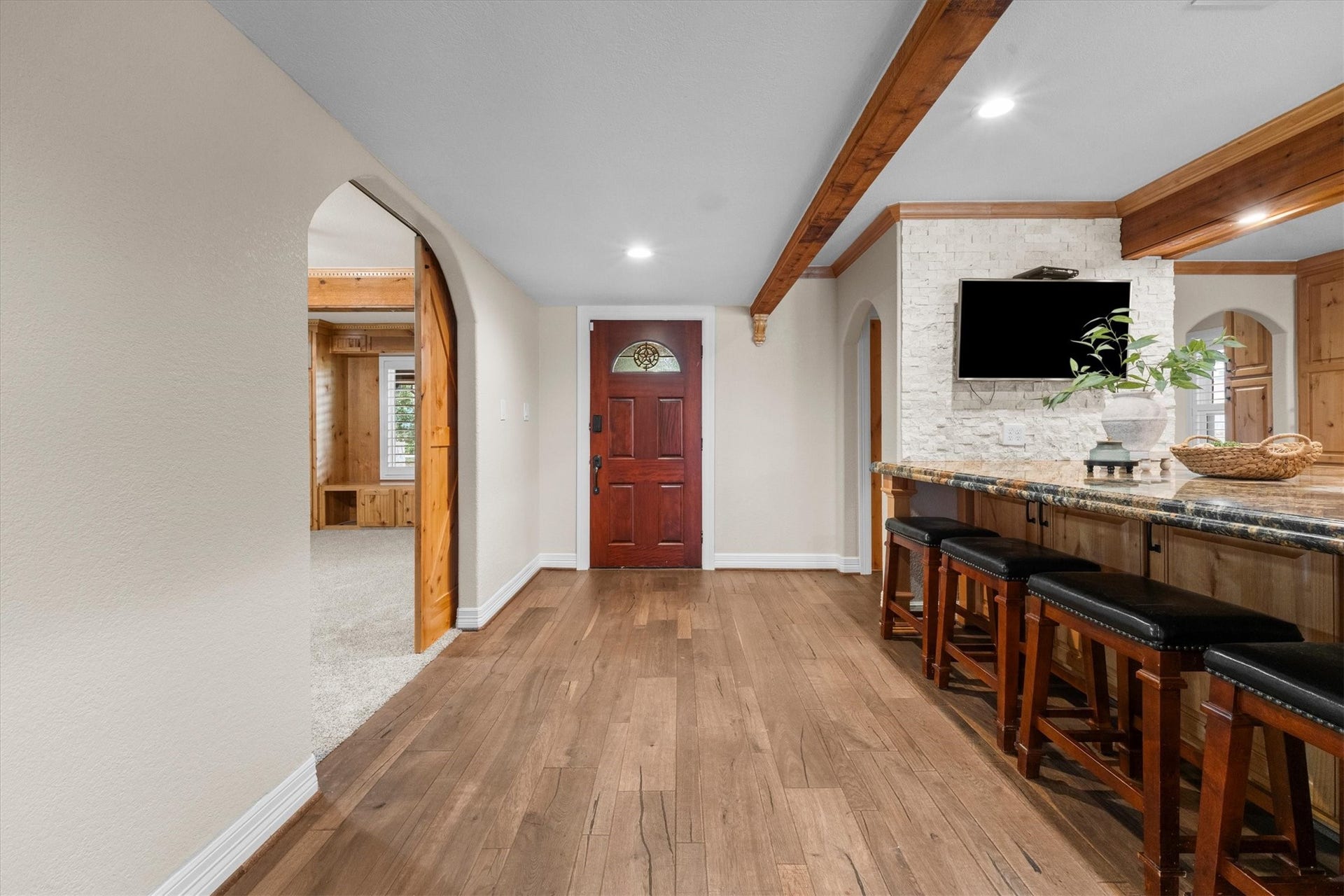 7119 Poole Road, Spring, TX 77379 A welcoming entry connects to the kitchen on one side and the game room on the other. The wood beams and stone accent add character and charm.