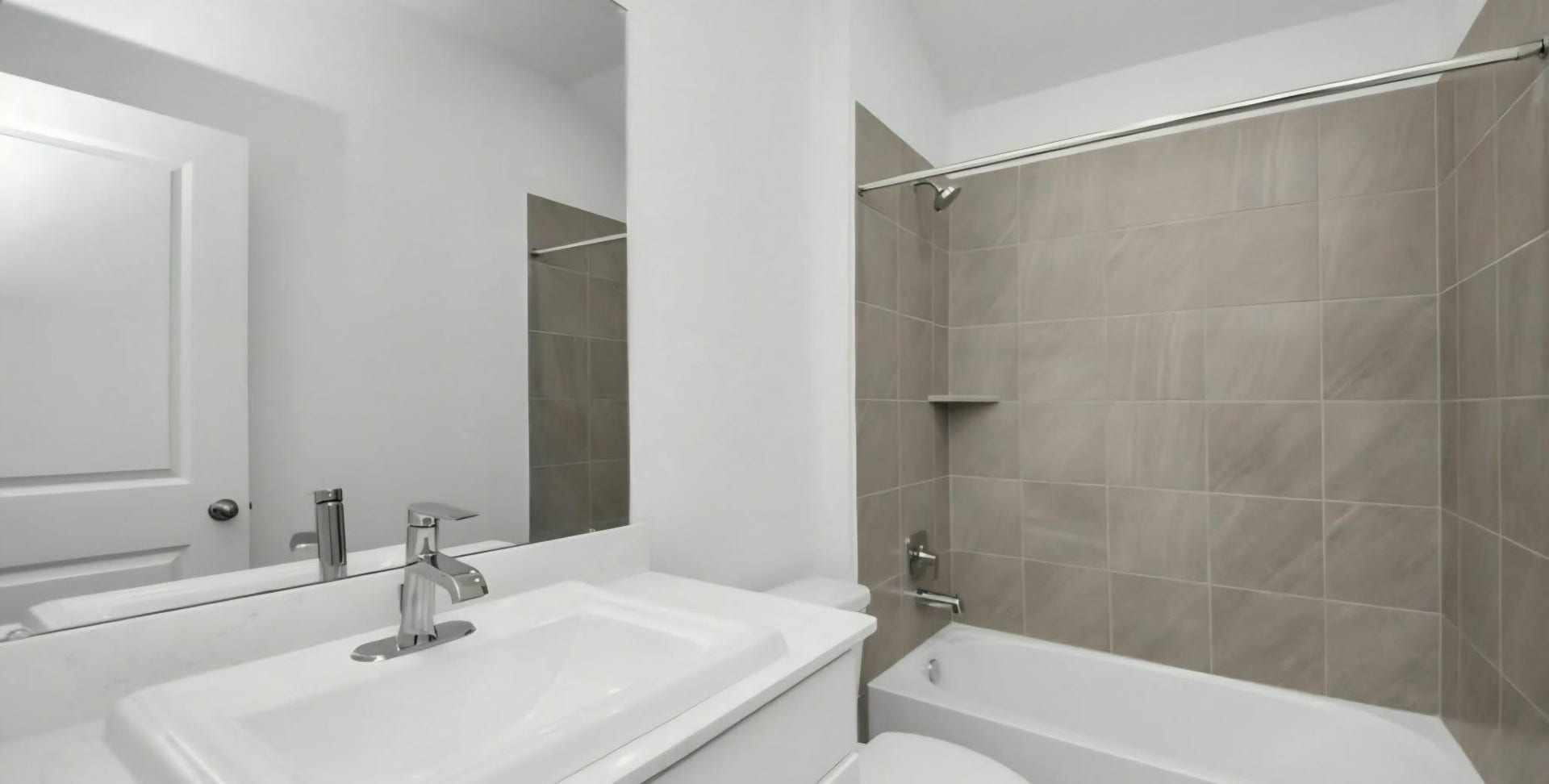 Full bathroom featuring a spacious vanity and tiled tub and shower combination.