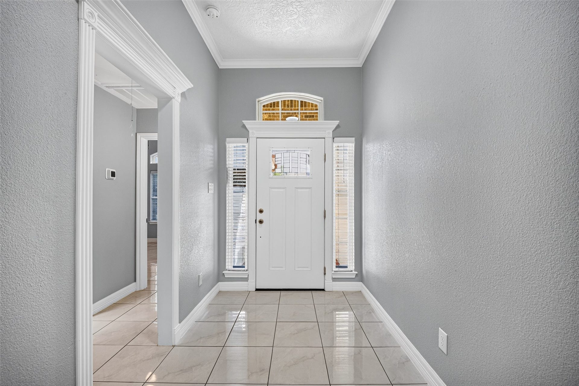 803 Avenue K, South Houston, TX 77587 Bright and inviting entryway featuring elegant tile flooring, a charming white front door with sidelights, and a transom window for added natural light.