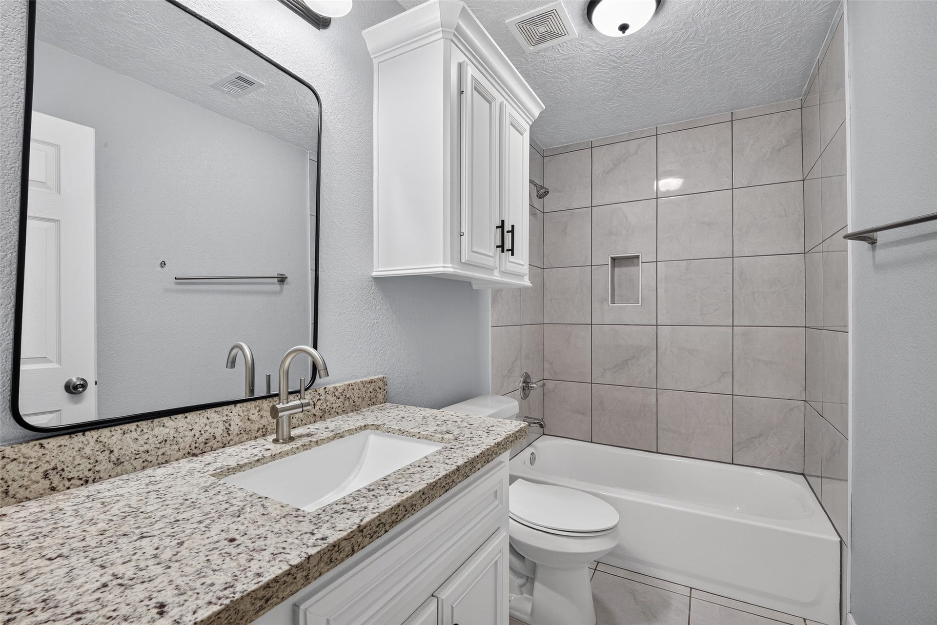 803 Avenue K, South Houston, TX 77587 Modern bathroom featuring a sleek granite countertop, elegant tile backsplash, and a convenient shower-tub combination.
