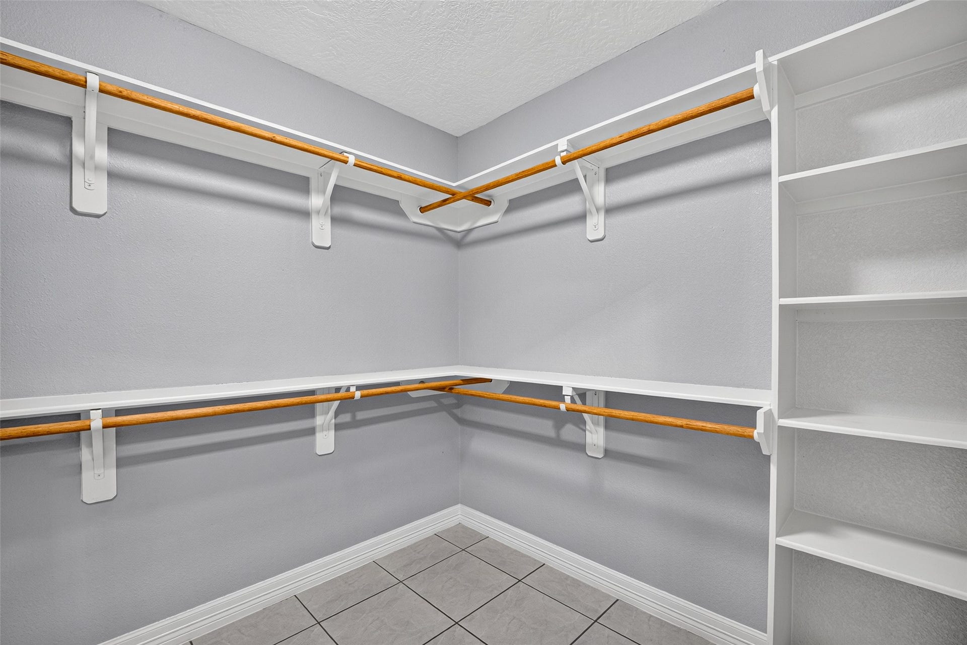 803 Avenue K, South Houston, TX 77587 Spacious walk-in closet with ample shelving and hanging space, featuring a neutral color palette and tile flooring for a clean, organized look.