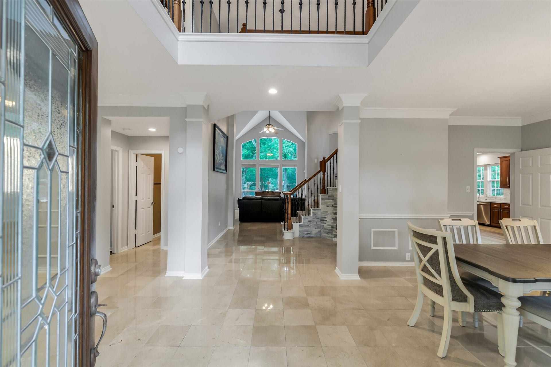 7 Larkspur Trail, The Woodlands, TX 77382 Stunning foyer with high ceilings and elegant tile flooring leads to a spacious living area, featuring a grand staircase and abundant natural light.