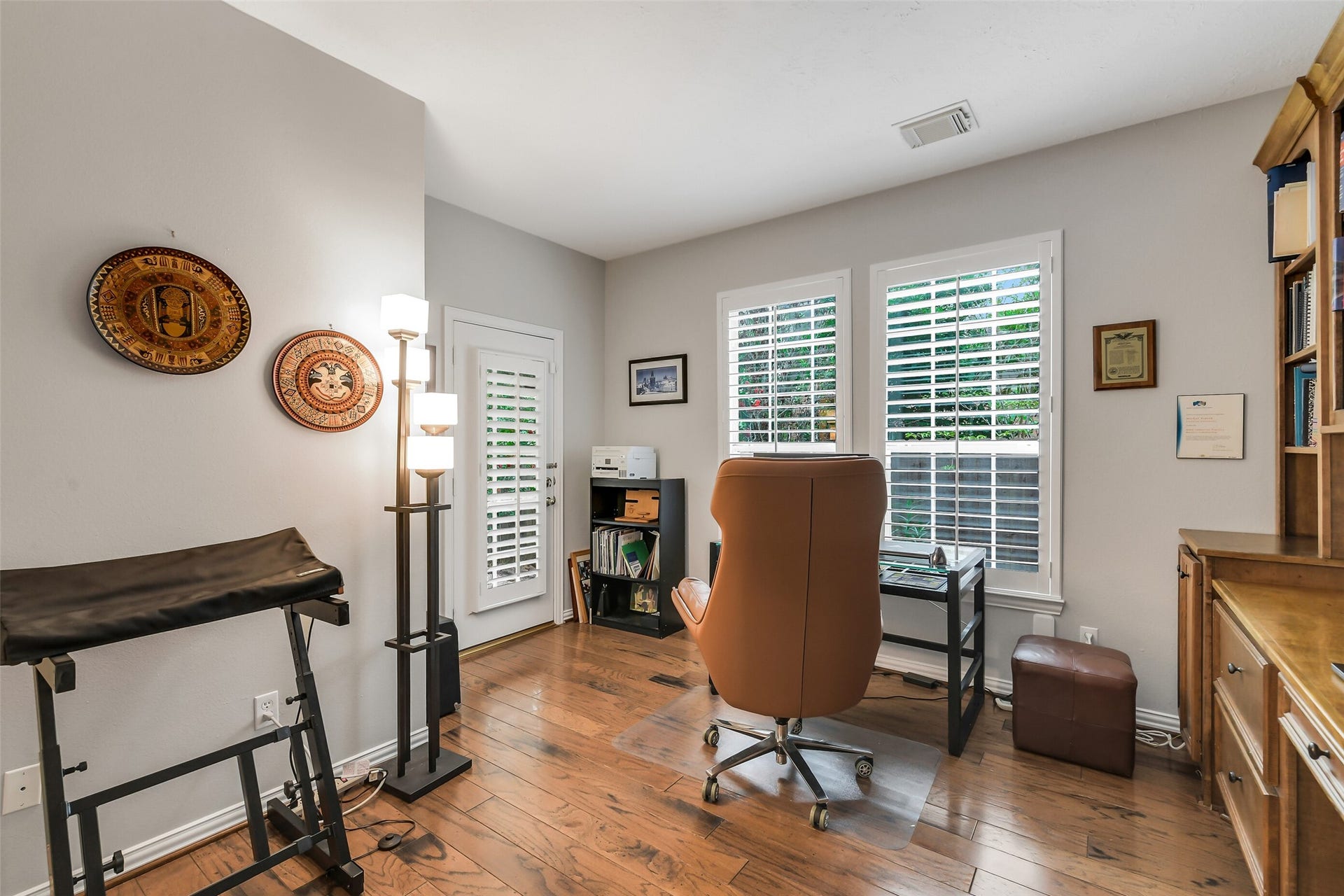7 Larkspur Trail, The Woodlands, TX 77382 Home office featuring hardwood floors, abundant natural light through large windows with shutters, and ample space for a comfortable workspace setup. Has seperate entrance to front verandah.
