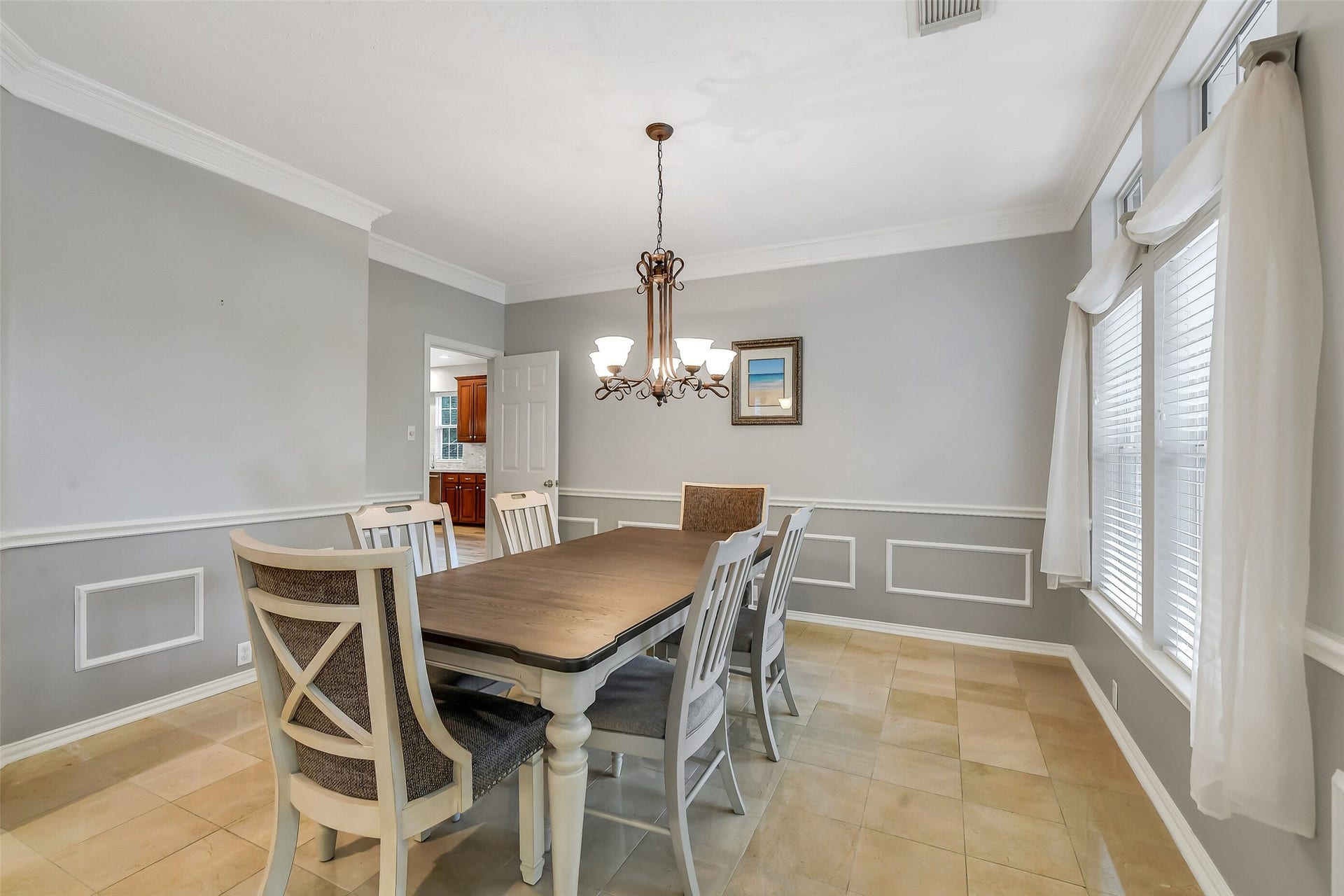7 Larkspur Trail, The Woodlands, TX 77382 Elegant dining room with a spacious table, stylish chandelier, and large windows that fill the space with natural light.