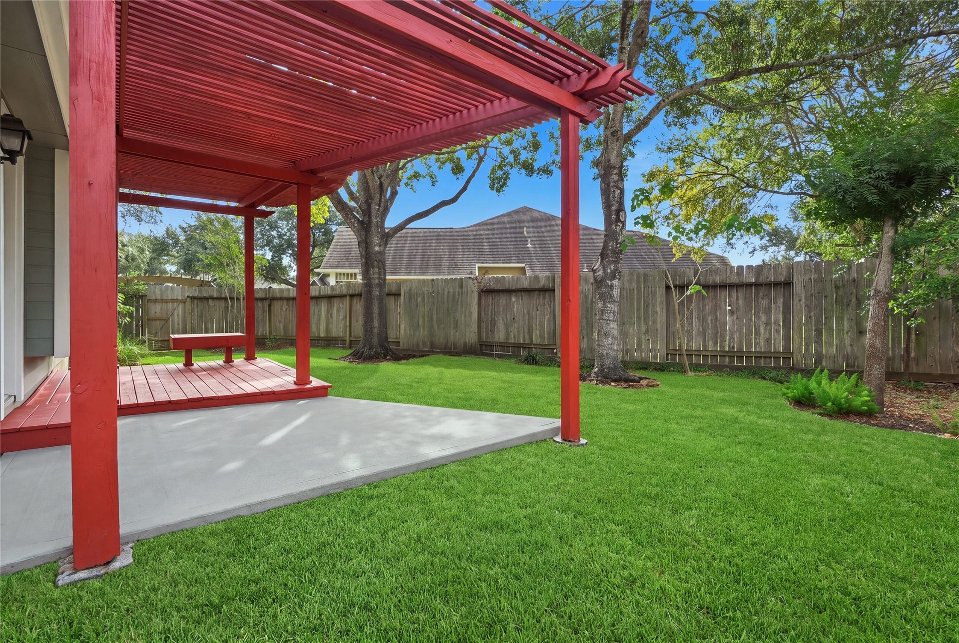 1411 Pebble Banks Lane, Seabrook, TX 77586 Shaded by a grand mature tree surrounded by river rock landscaping, offering an ideal outdoor space for entertaining or relaxation.