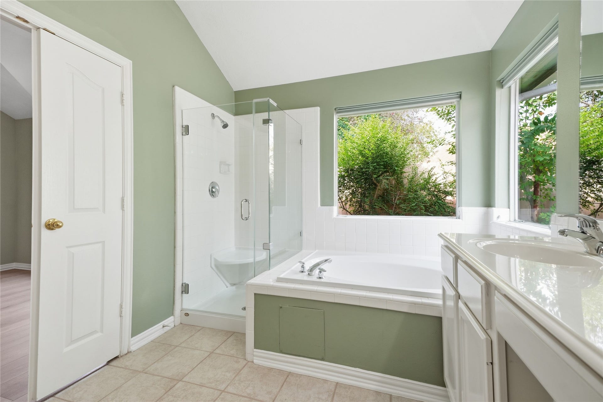 1411 Pebble Banks Lane, Seabrook, TX 77586 Complete with a separate glass enclosed shower featuring built-in seating, a deep soaking garden tub under sunny corner windows and tile flooring.