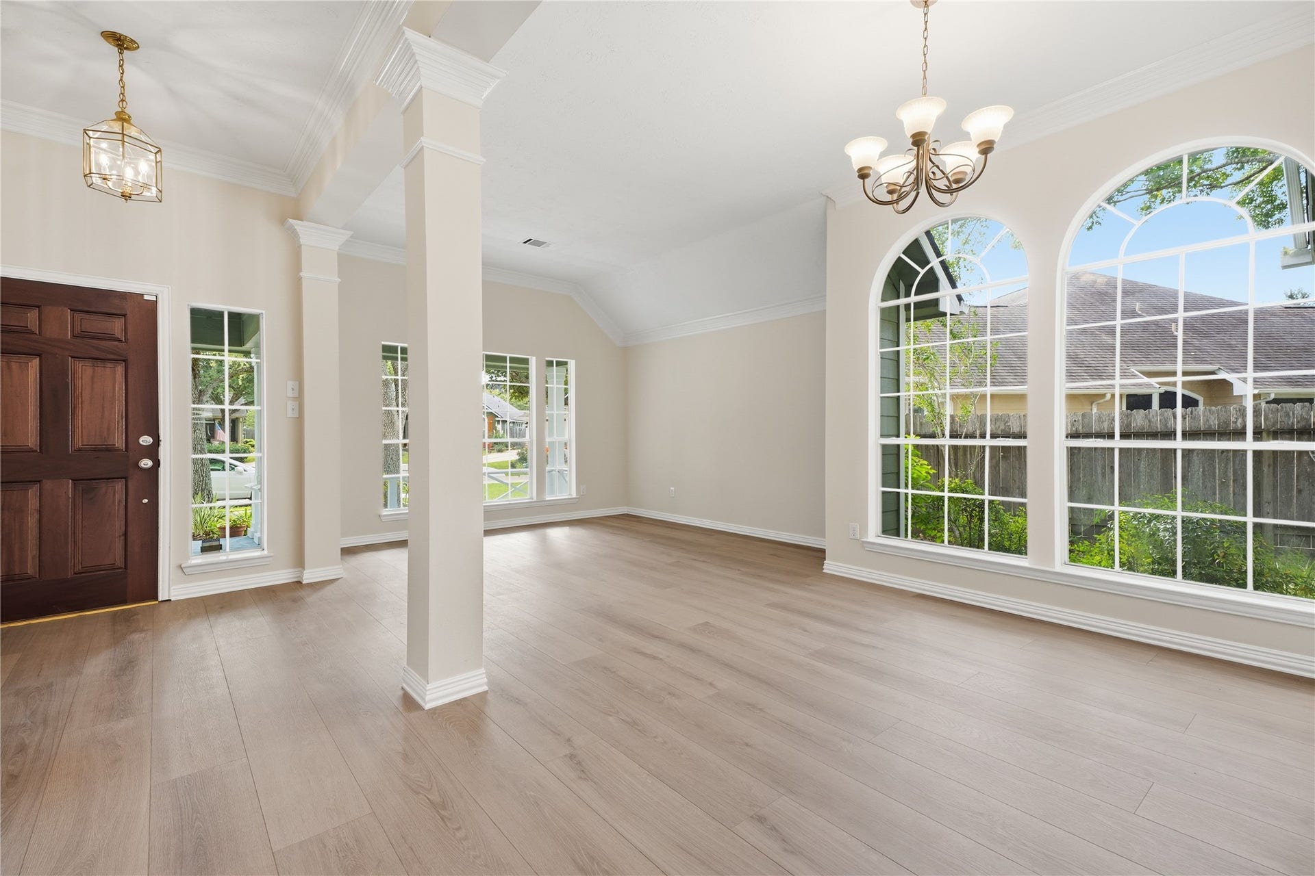 1411 Pebble Banks Lane, Seabrook, TX 77586 Light filled formal dining space features large arched windows and a classical chandelier, flowing naturally into the formal living room.