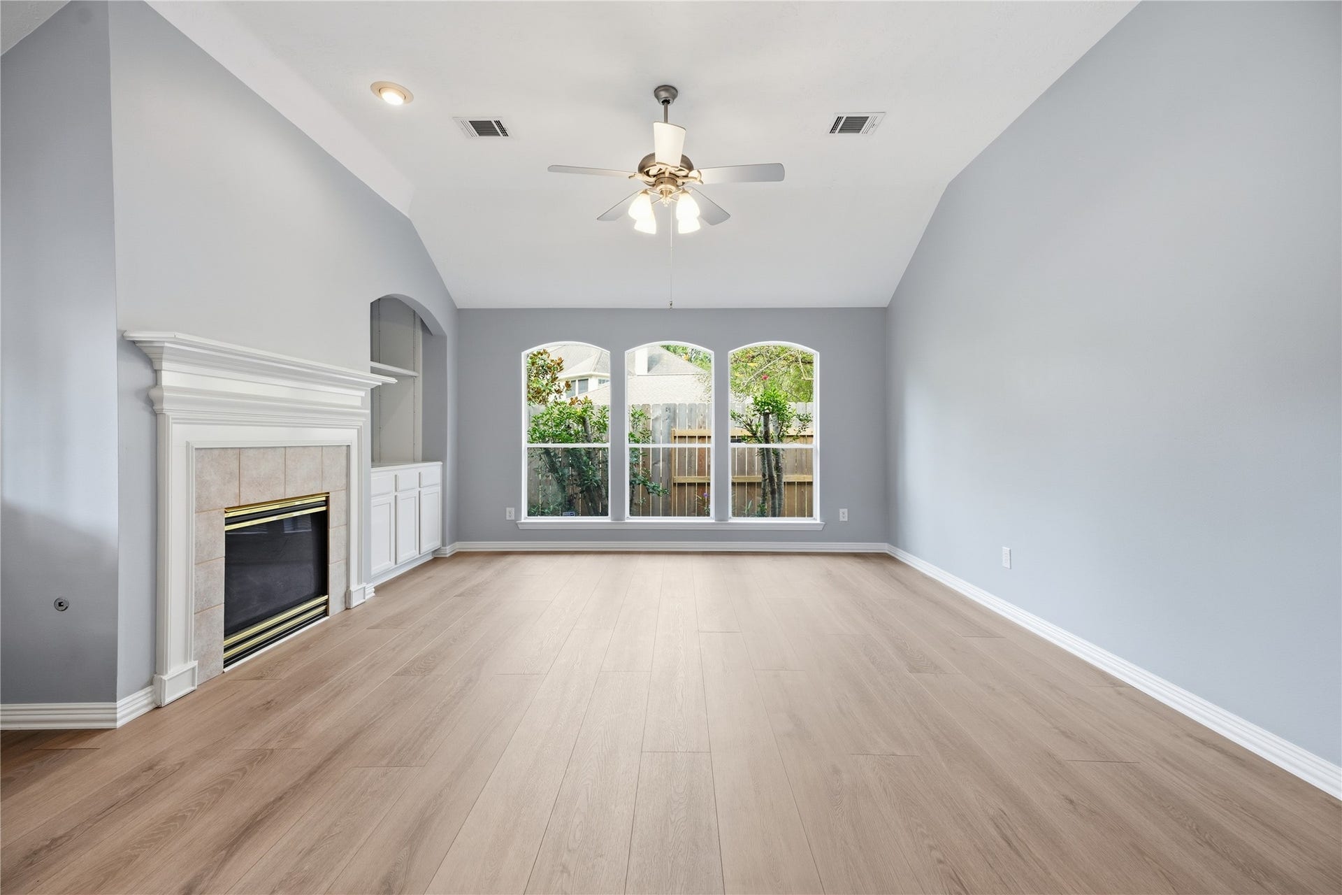 1411 Pebble Banks Lane, Seabrook, TX 77586 The family room is anchored by a cozy tile surround fireplace with mantle and custom built-in media cabinetry with an abundance of natural light from the large exterior windows.