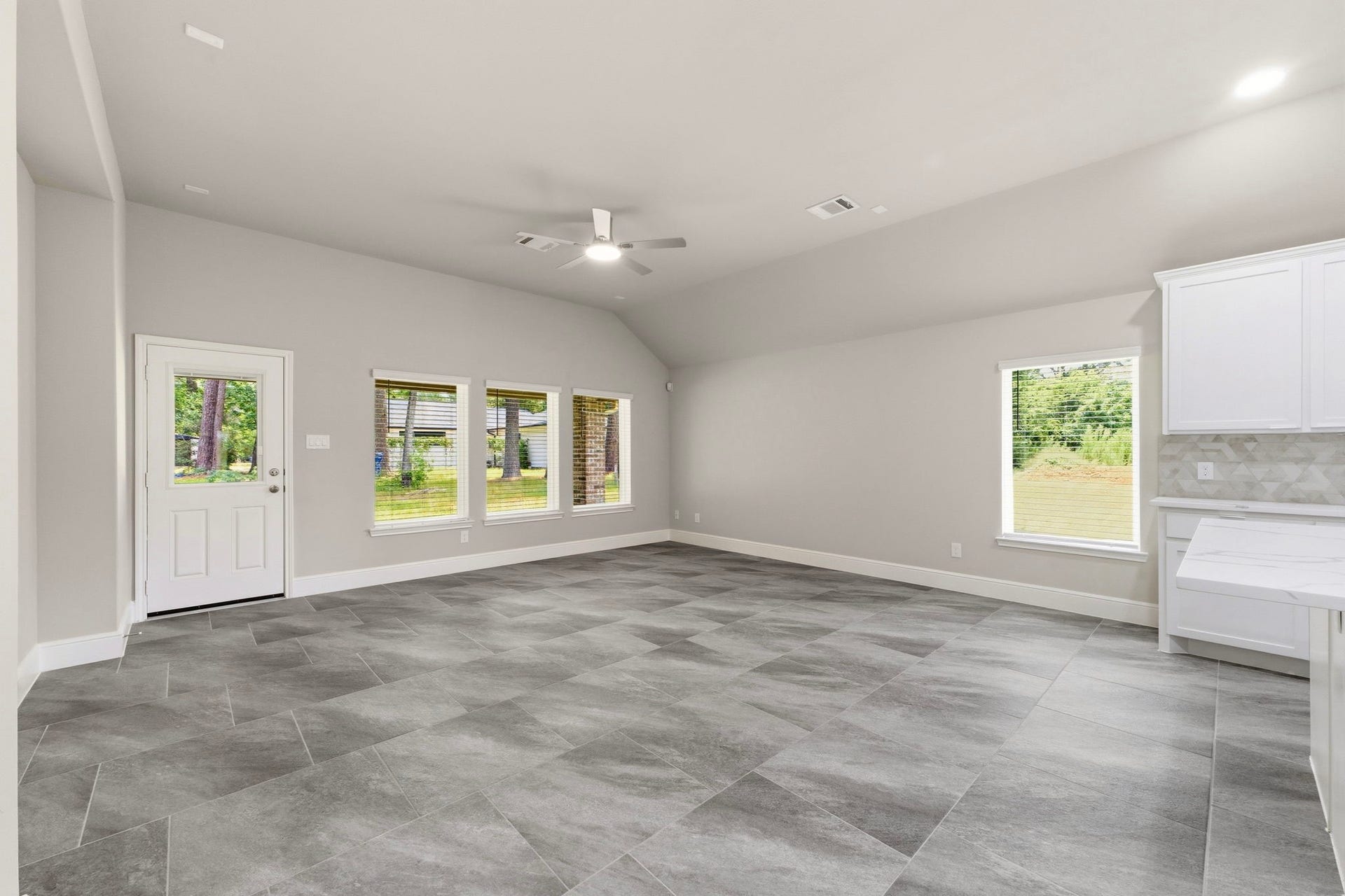 23620 Youpon Lane, Spring, TX 77389 Light filled living room with expansive windows, seamlessly open to the kitchen and dining area.