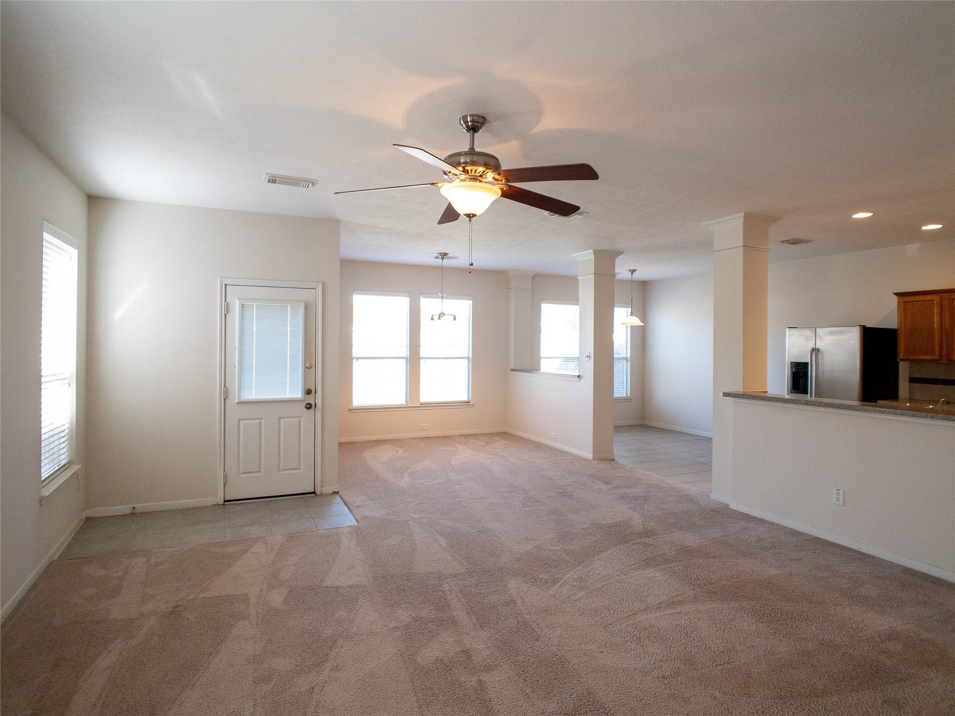 5406 Timber Court Hollow, Houston, TX 77084 living room with dining room and breakfast beyond, door to back yard, and kitchen to the right