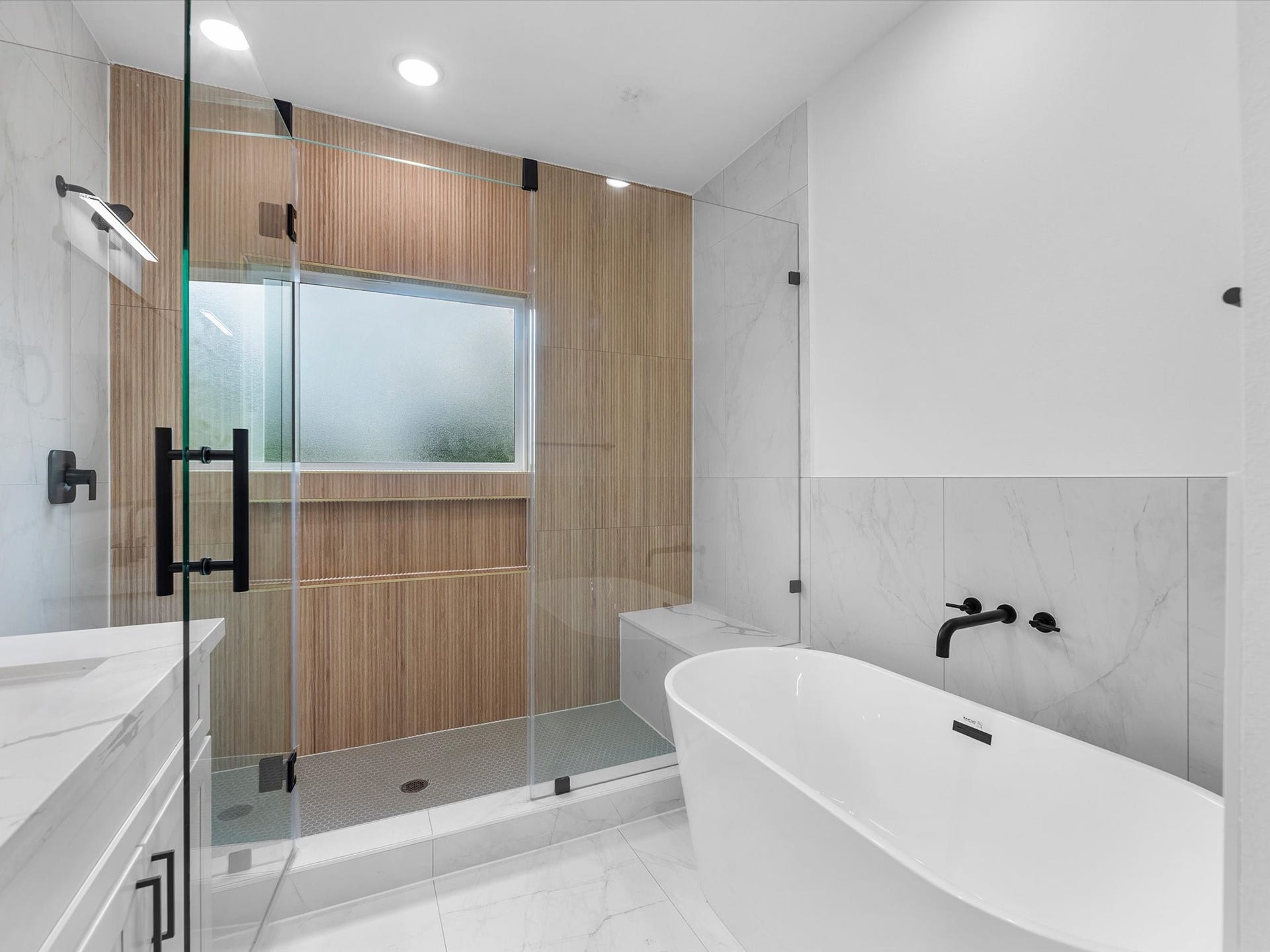 4804 Elysian St, #A/B, Houston, TX 77009 Luxurious bathroom featuring stylish accent walls in the shower and a sleek shower-tub combination. A designated vanity space adds extra functionality, while modern finishes and thoughtful details create a beautiful, spa-like feel.