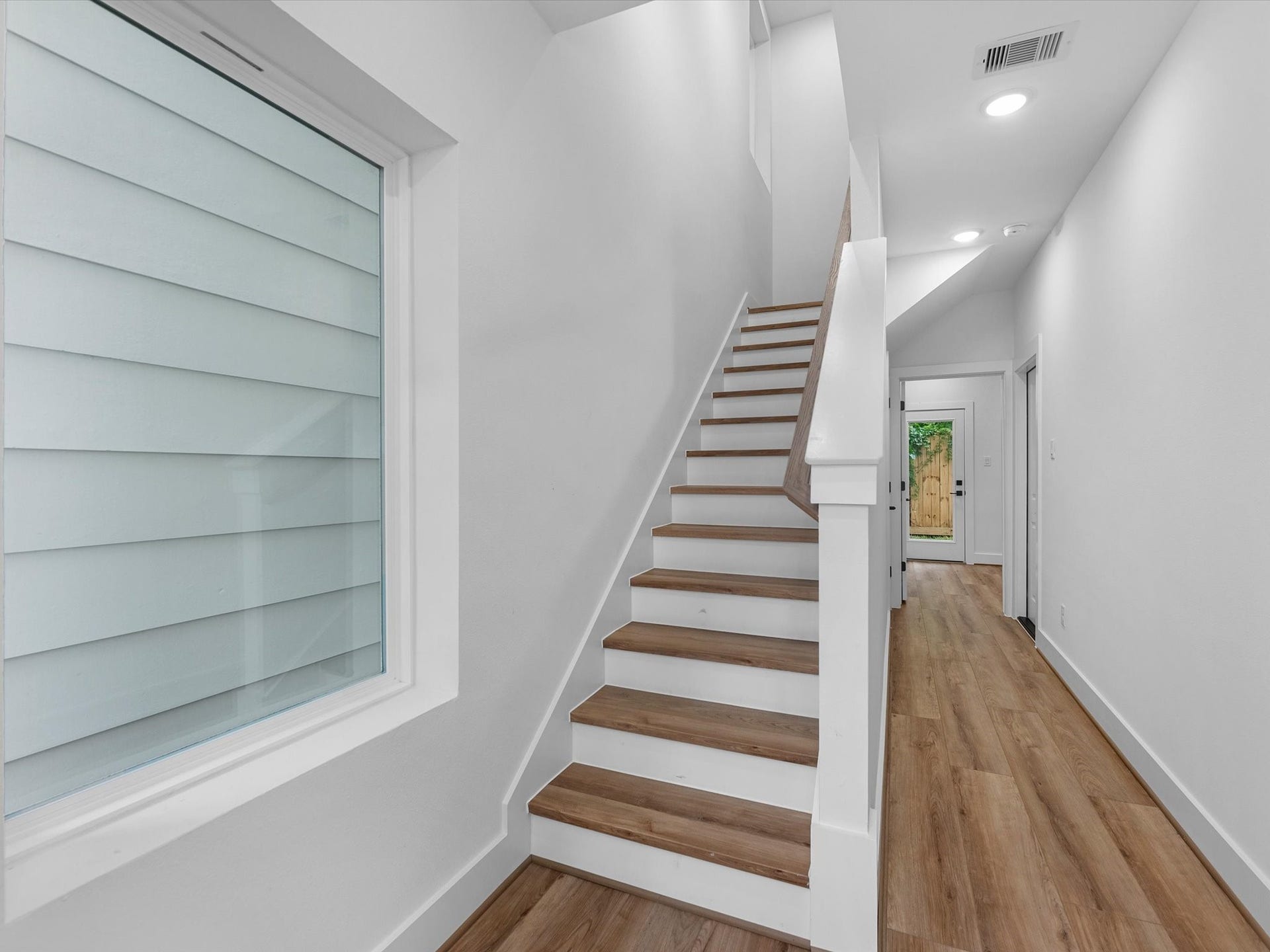 4804 Elysian St, #A/B, Houston, TX 77009 Welcoming entryway with a spacious closet and additional storage tucked neatly beneath the stairs. The first floor also features a bedroom with a full bath and direct access to the backyard, offering added convenience and privacy.