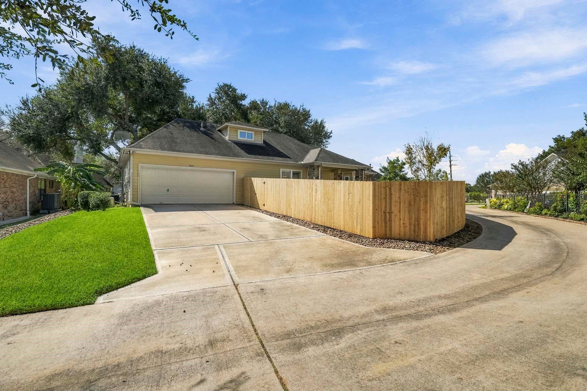 4631 Lake Village Drive, Fulshear, TX 77441 Tucked away from the street, a private drive leads to the home's driveway and 2-car Garage, offering both convenience and a heightened sense of privacy. A decorative rock-lined perimeter traces the fence line, adding a polished finishing touch to the landscape while supporting proper drainage and low-maintenance outdoor living.
