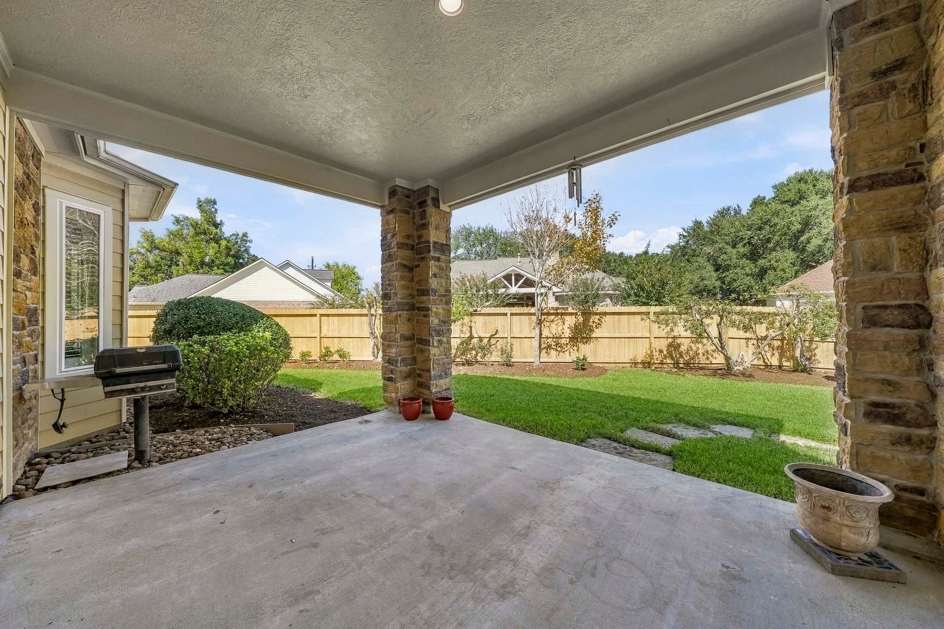 4631 Lake Village Drive, Fulshear, TX 77441 This covered Back Patio creates the perfect outdoor retreat, thoughtfully appointed with a built-in gas grill, stacked stone pillars, and recessed lighting for effortless day-to-night enjoyment. Surrounded by an abundance of privacy, the space offers an inviting setting for everything from casual family dinners to memorable gatherings with friends.