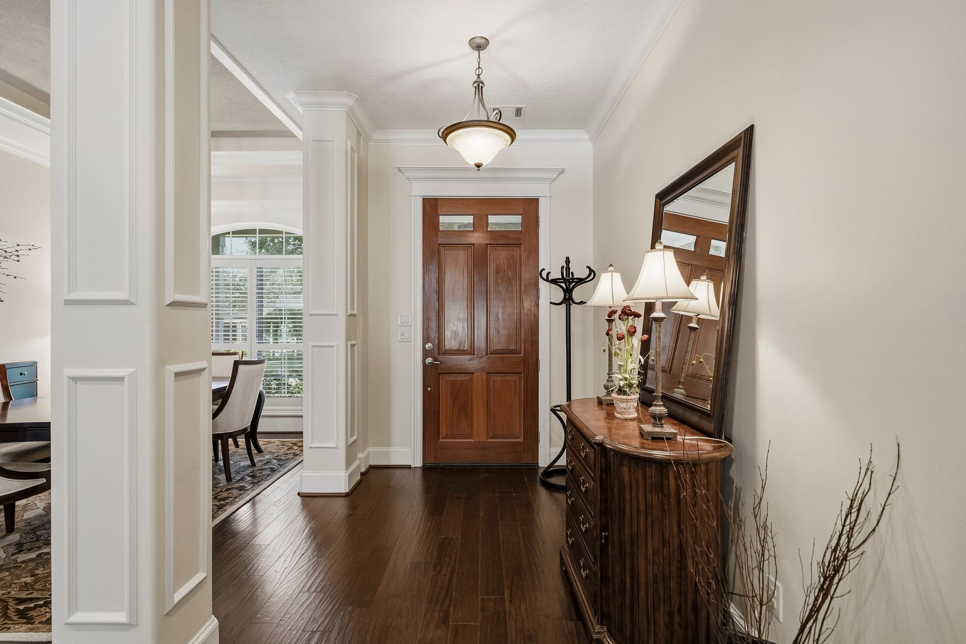 4631 Lake Village Drive, Fulshear, TX 77441 This look back showcases the spacious and airy Foyer, where crown molding, elegantly cased pillars, and a solid wood Front Door create a warm yet sophisticated first impression. Generous in size and thoughtfully designed, the space offers ample room for a bench, coat rack, console, or additional storage piece, blending beauty with everyday functionality.