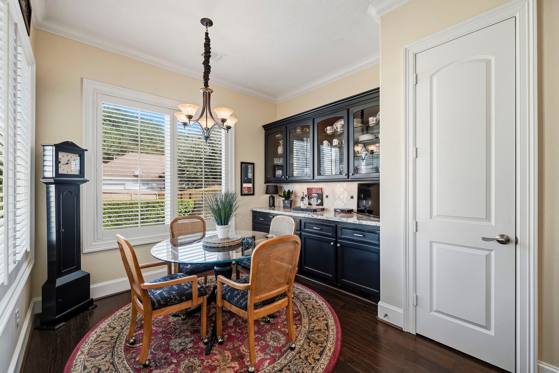 4631 Lake Village Drive, Fulshear, TX 77441 The Breakfast Room is enhanced by a custom built-in Butlers Pantry, thoughtfully designed with rich dark cabinetry, glass-front upper cabinets, a granite countertop, and a decorative tile backsplash. Equal parts beautiful and functional, this versatile space is perfectly suited for a stylish coffee bar, beverage station, or serving area when entertaining. Just beyond, a huge walk-in Pantry offers built-in shelving and abundant storage.
