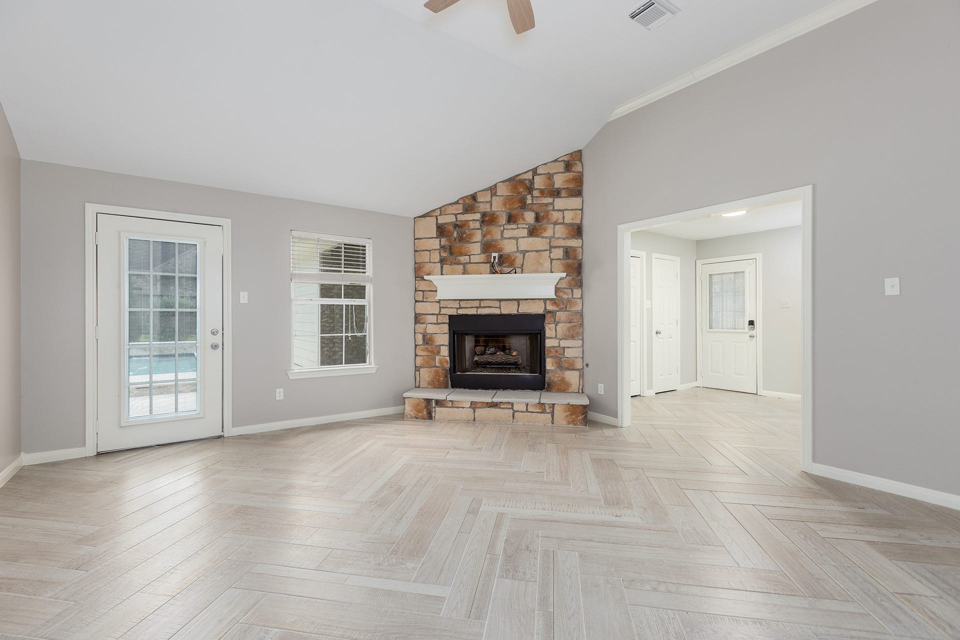 12830 Point Aquarius Boulevard, Willis, TX 77318 Living room and kitchen with beautiful herringbone hand laid tile and stone fireplace.