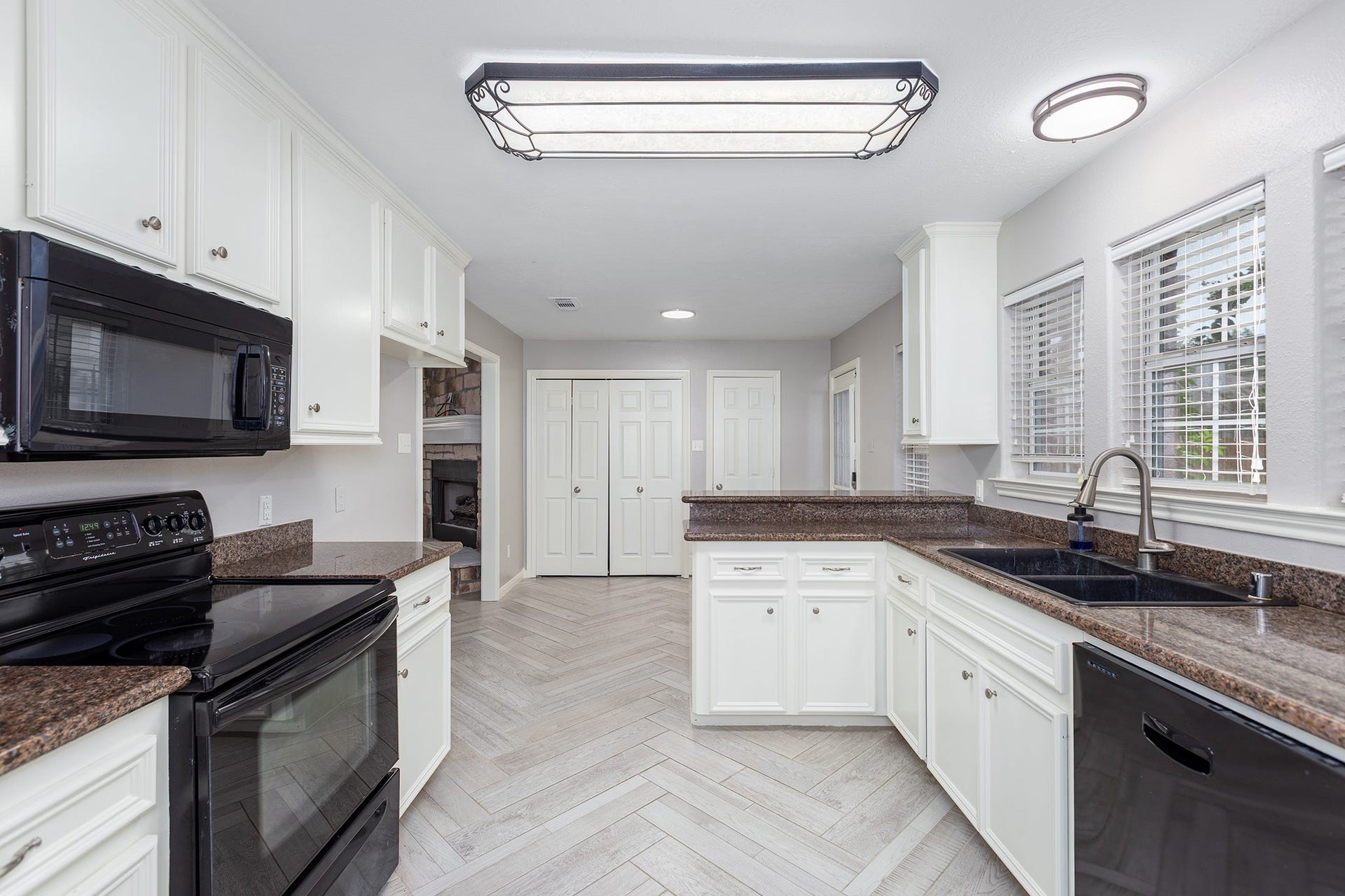 12830 Point Aquarius Boulevard, Willis, TX 77318 Herringbone tiles flow through the kitchen into the living room seamlessly.