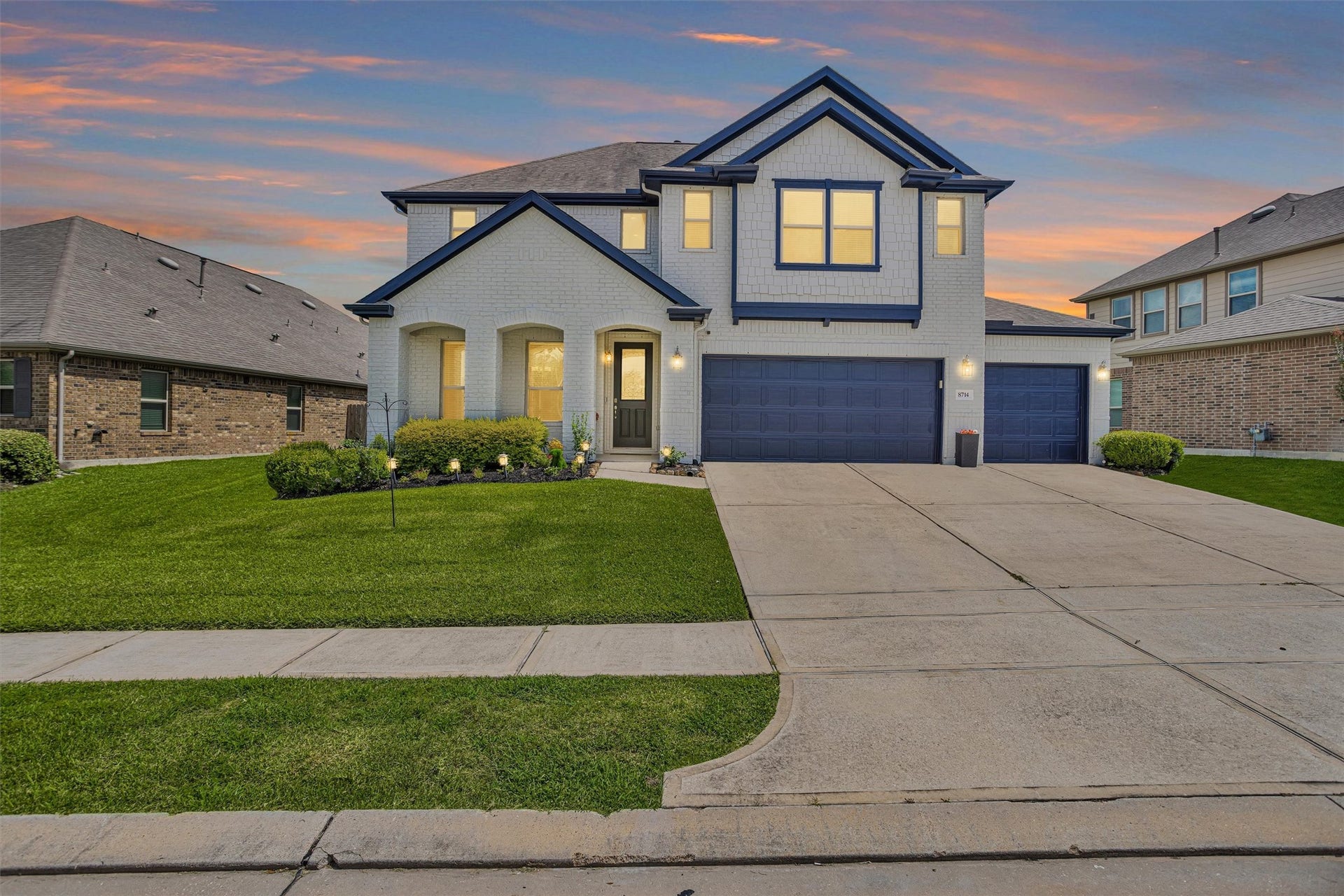 8714 Ute Creek Lane, Magnolia, TX 77354 Front elevation at dusk with 3-car garage.