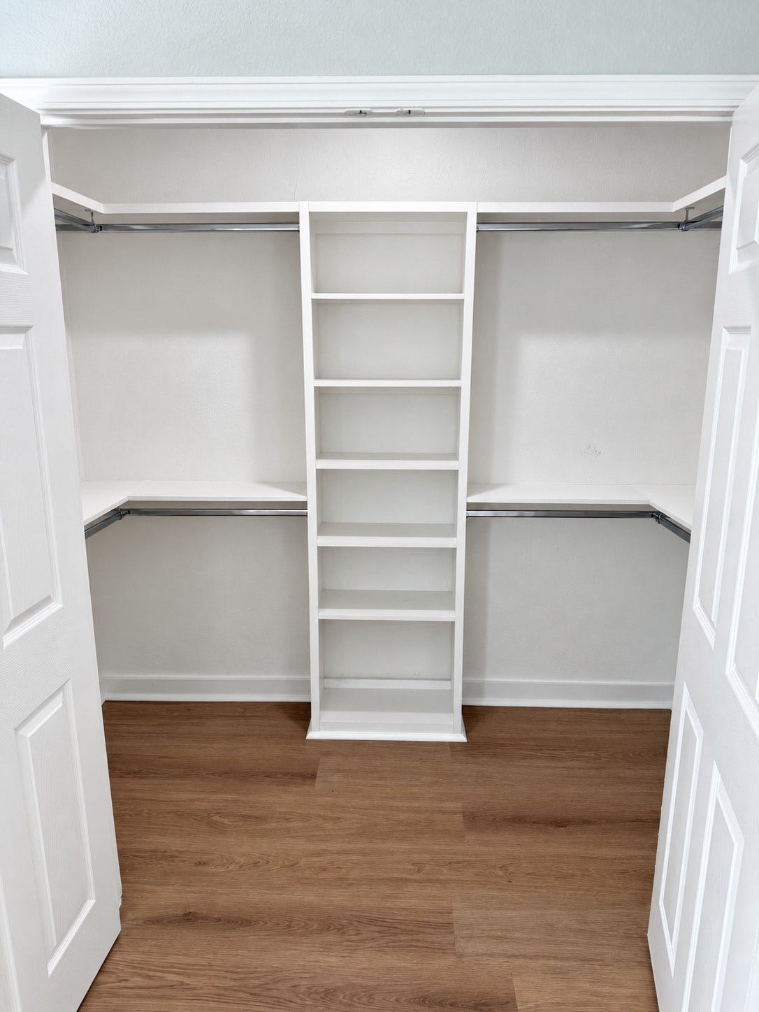 Closet storage includes central shelving and two levels of hanging space.