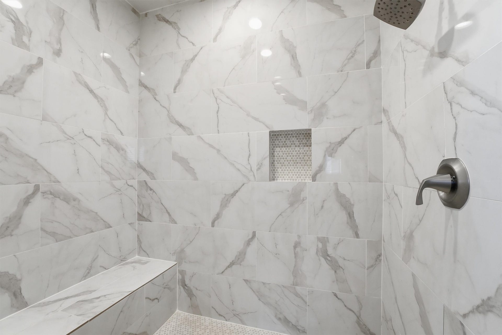438 Amanda Circle, Tiki Island, TX 77554 Wrapped in striking tilework, the
walk-in shower brings a polished
designer touch to the primary
bath and adds to the luxurious
feel of this private ensuite.