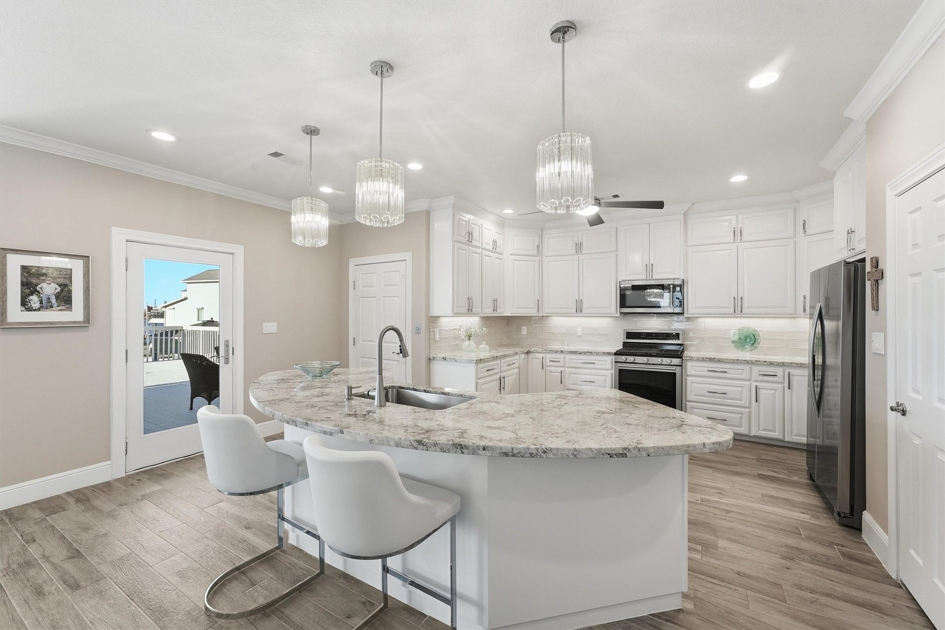 438 Amanda Circle, Tiki Island, TX 77554 The generous island creates a natural centerpiece for the open kitchen, offering bar seating, ample prep space, and an easy connection to the dining and living areas.