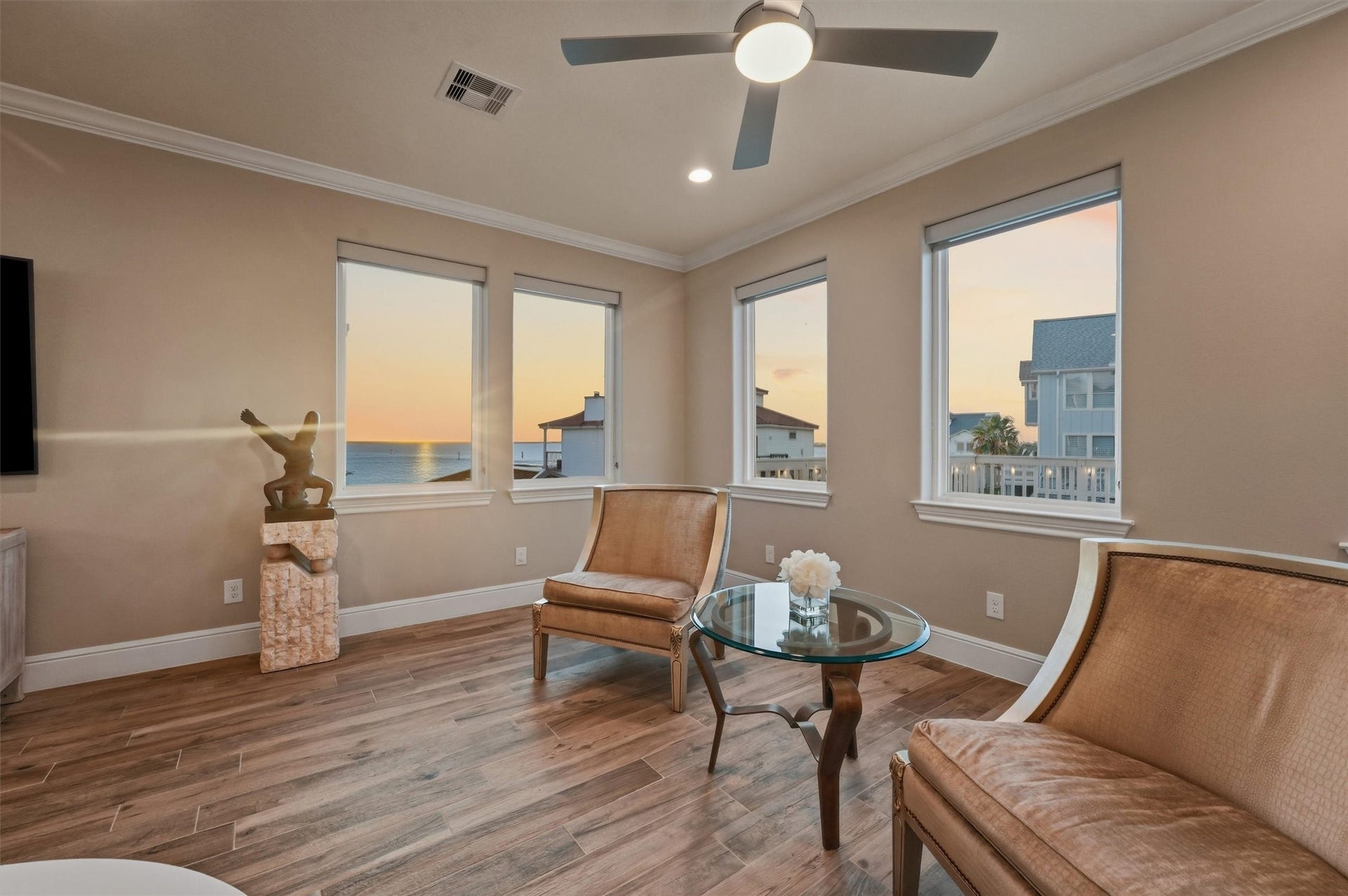 438 Amanda Circle, Tiki Island, TX 77554 Soft evening light and glowing sunset views give this inviting sitting area a peaceful waterfront ambiance made for quiet conversation and laid-back coastal living.