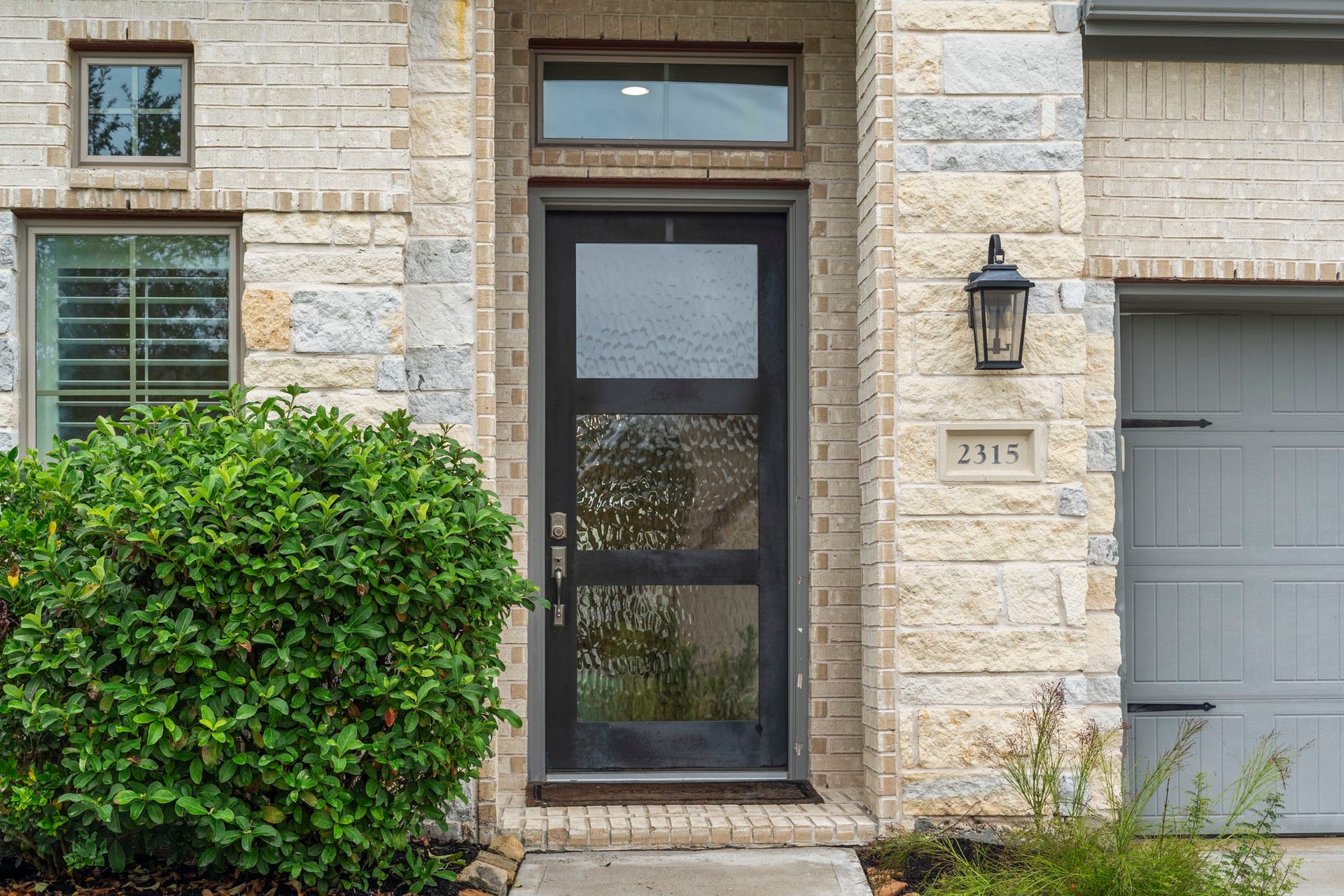 2315 Calm Channel Court, Missouri City, TX 77459 A striking black front door with stylish obscure glass and a transom window adds a sleek, modern touch.