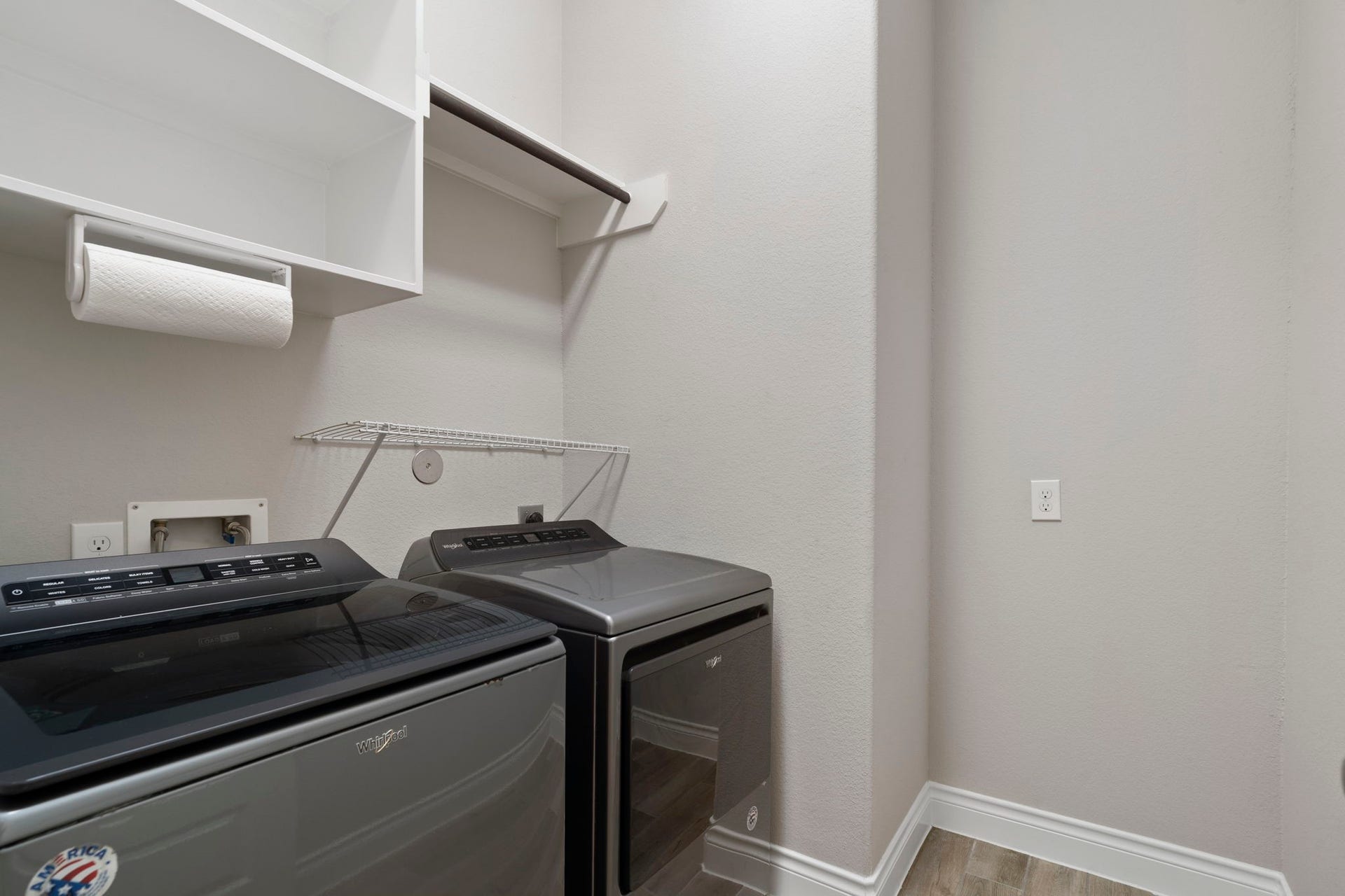 2315 Calm Channel Court, Missouri City, TX 77459 In-home laundry room featuring storage shelving and a hanging rack. Washer and dryer are included in the sale.