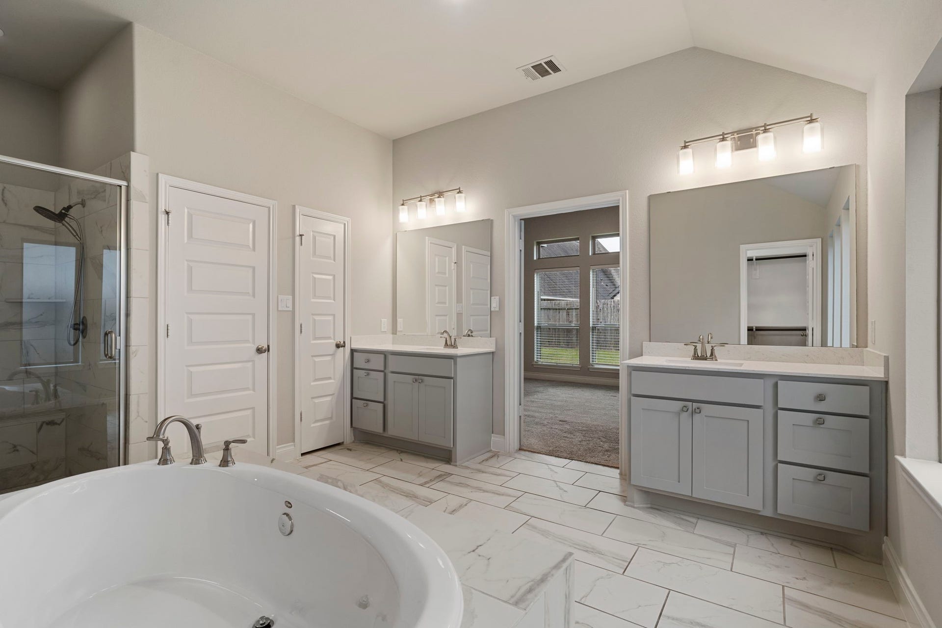 2315 Calm Channel Court, Missouri City, TX 77459 The luxurious owner's bath features dual vanities, a garden tub, a separate glass-enclosed shower, and TWO spacious walk-in closets.