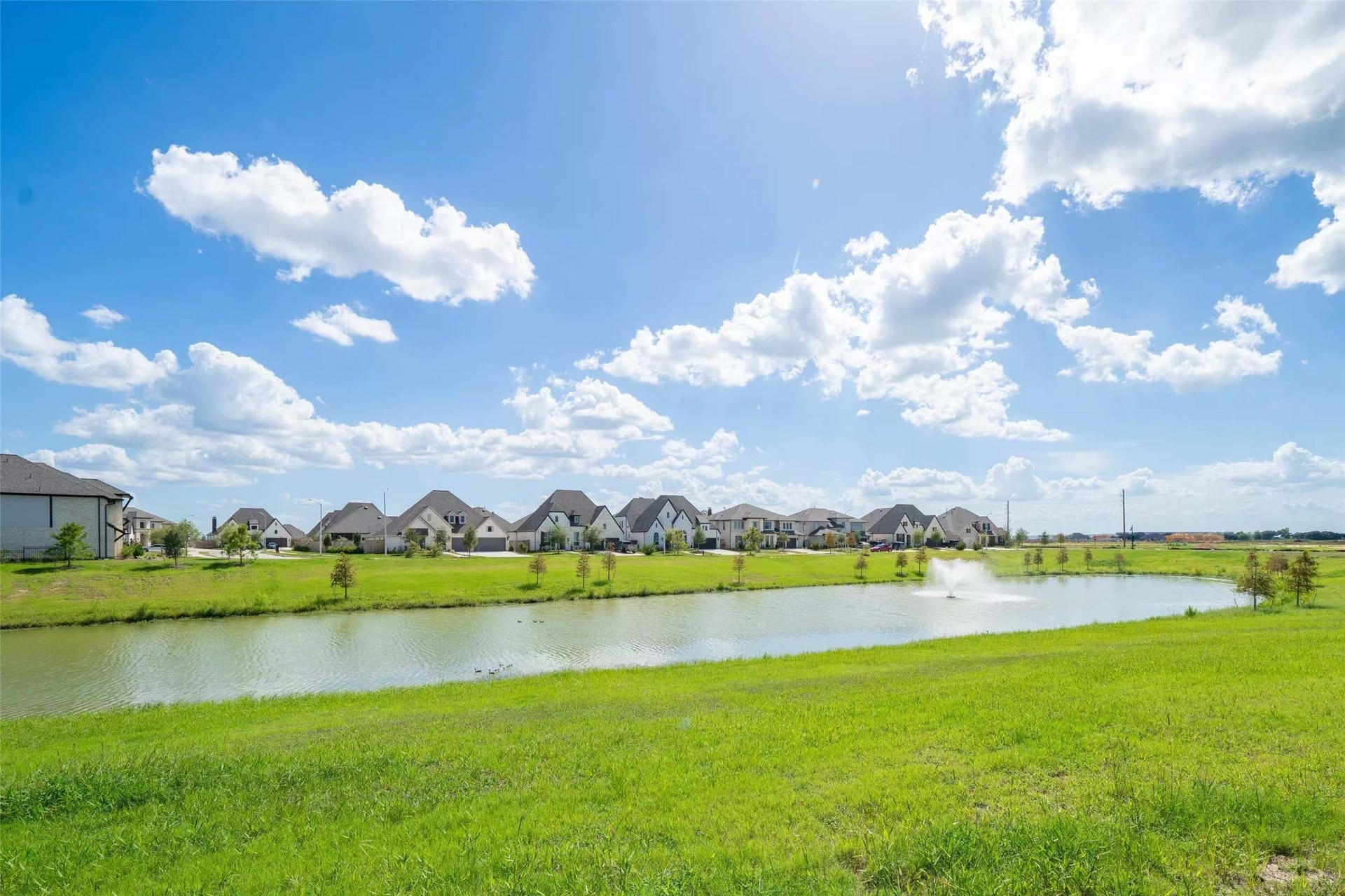 Beautiful lakefront setting featuring peaceful water views, a scenic fountain, and lush green space. Enjoy the relaxing atmosphere and picturesque surroundings right in your backyard!