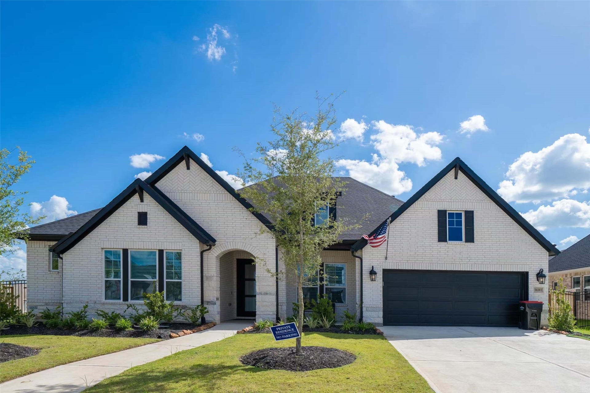 Beautiful 2025 David Weekley Augustine floor plan featuring timeless architectural design, elegant white brick exterior, striking black accents, charming arched entryway, and a spacious four-car garage. A stunning single-story home with exceptional curb appeal!