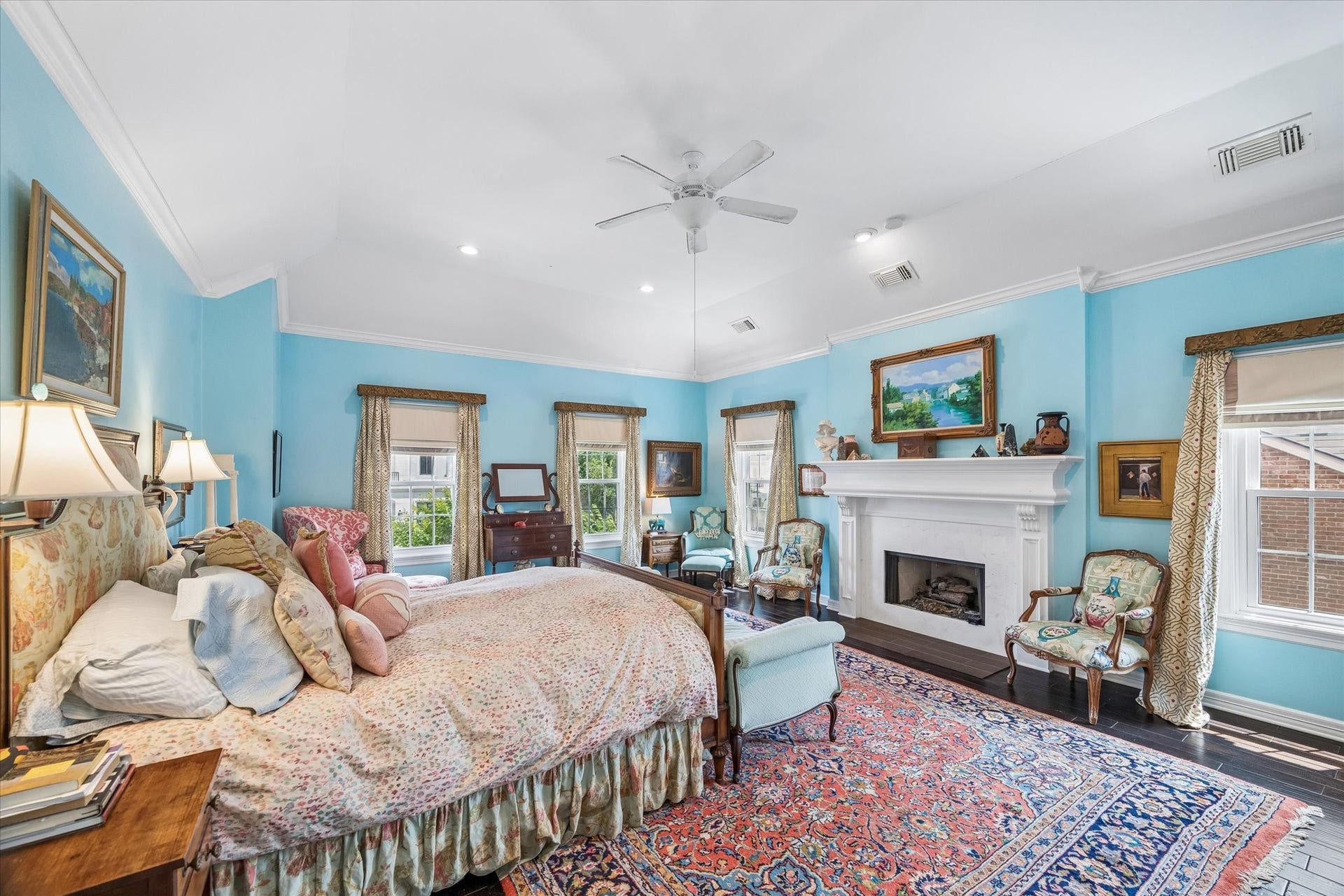 2120 Potomac Drive, #A, Houston, TX 77057 The primary bedroom is a serene retreat. A large fireplace adds an extra layer of comfort and walls of windows bring in natural light!