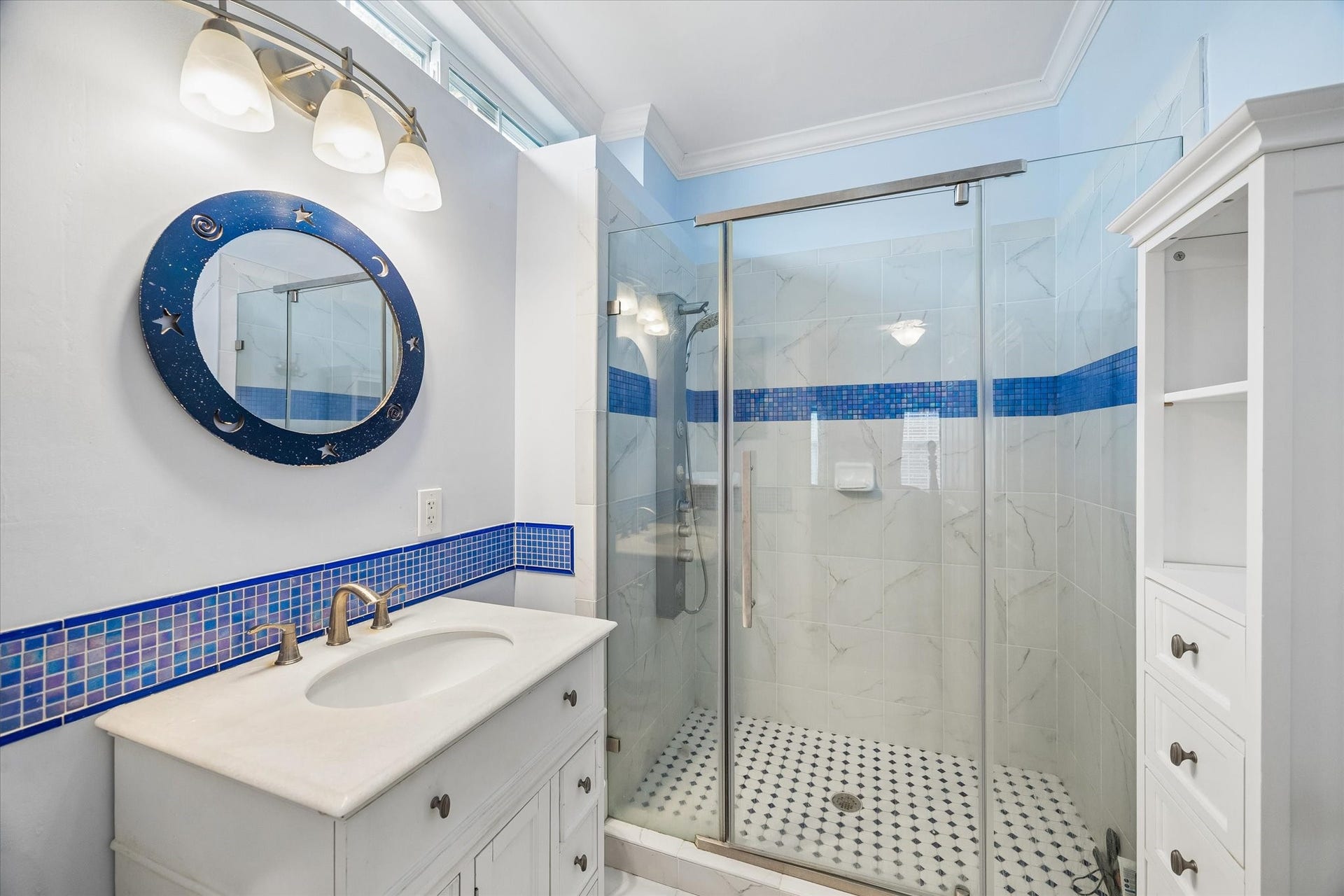 2120 Potomac Drive, #A, Houston, TX 77057 Gorgeous en-suite! Features a large standing shower, blue tile accents, and windows just below the ceiling to bring in natural light without sacrificing privacy.