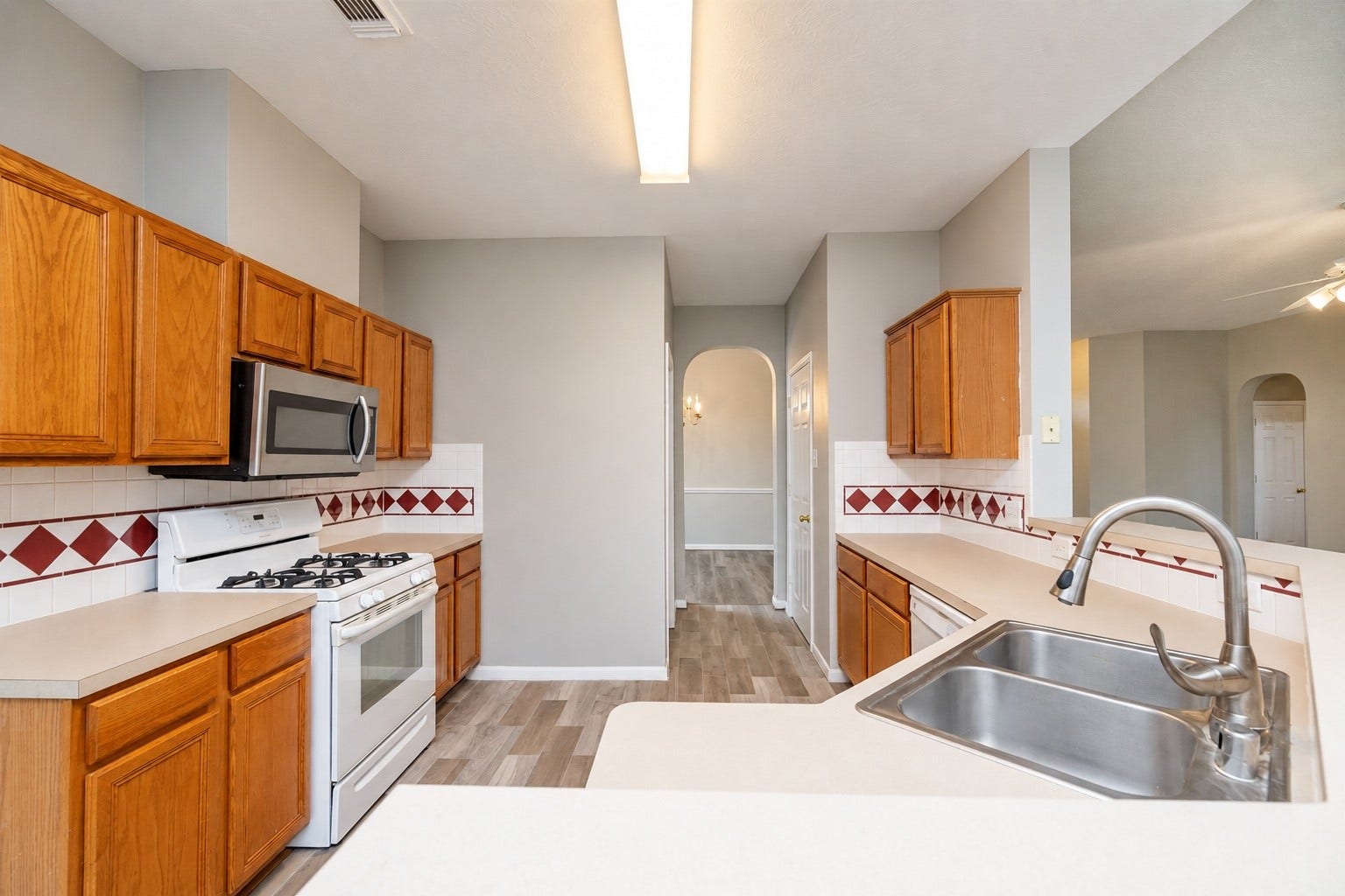 3003 Grey Mist Court, Friendswood, TX 77546 Spacious kitchen with ample cabinet and counter space, breakfast bar, double sink, and open views into the living area.
